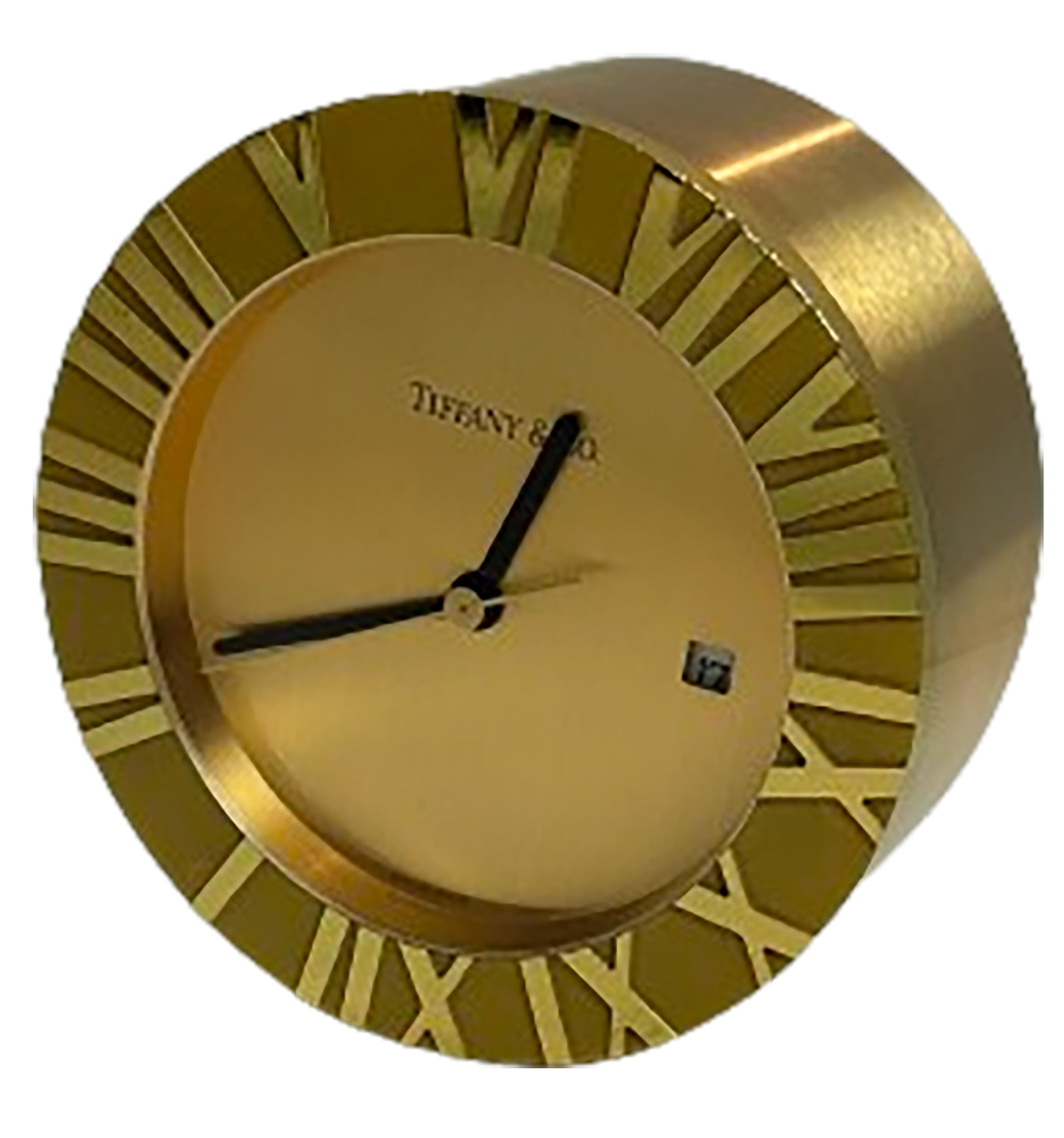 A stunning Tiffany & Co. Swiss made gold and brass atlas table clock. Crafted with high-quality materials and a battery-powered quartz mechanism. Brass plated exterior with inlaid gold on the inside. Roman numerals on the outer edge. Small rotating