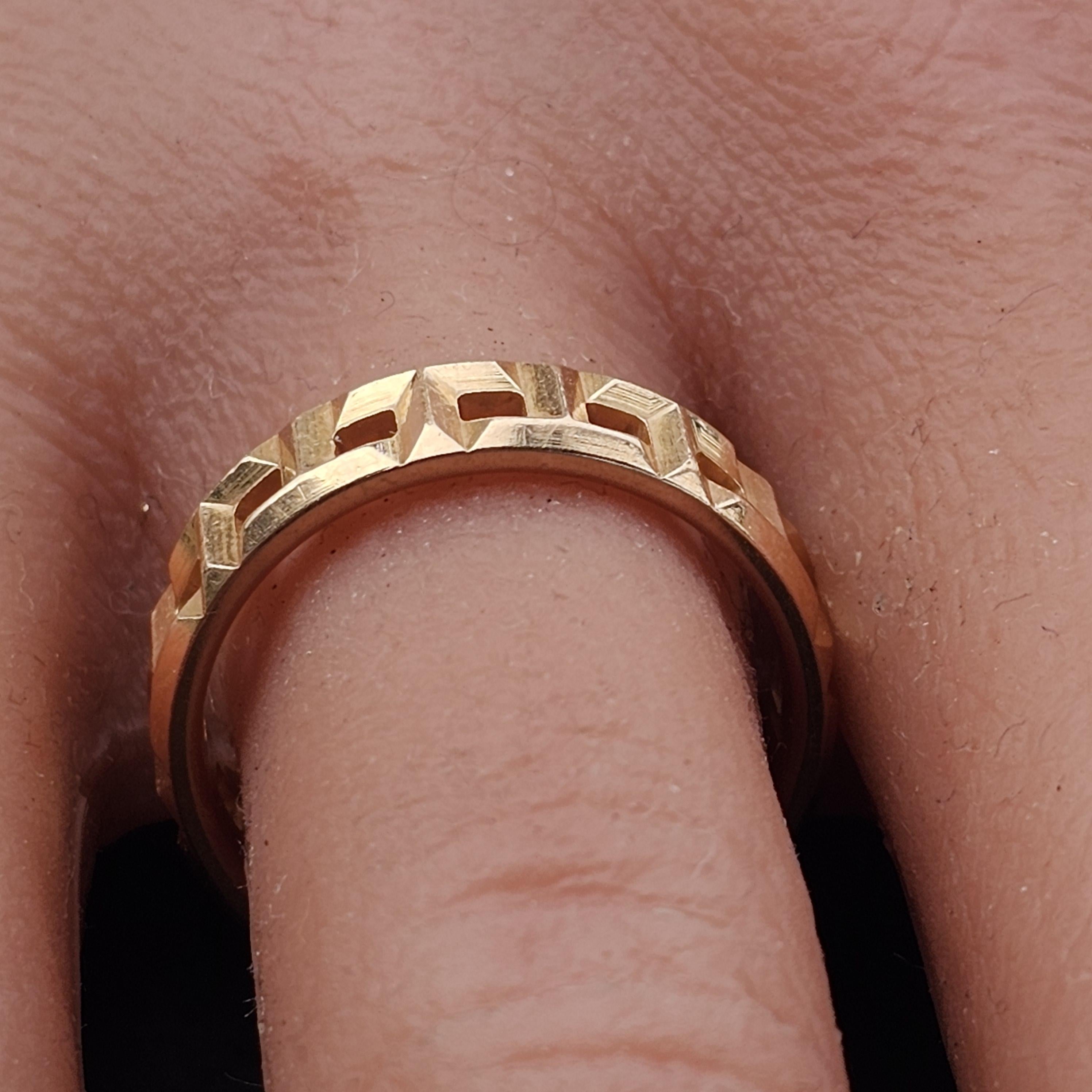 Este anillo con banda de Tiffany & Co. ejemplifica la elegancia moderna. Fabricado en oro rosa de 18 quilates, presenta un diseño geométrico calado que le da un toque arquitectónico único. El anillo es de la talla 7, con una anchura de 5,5 mm,