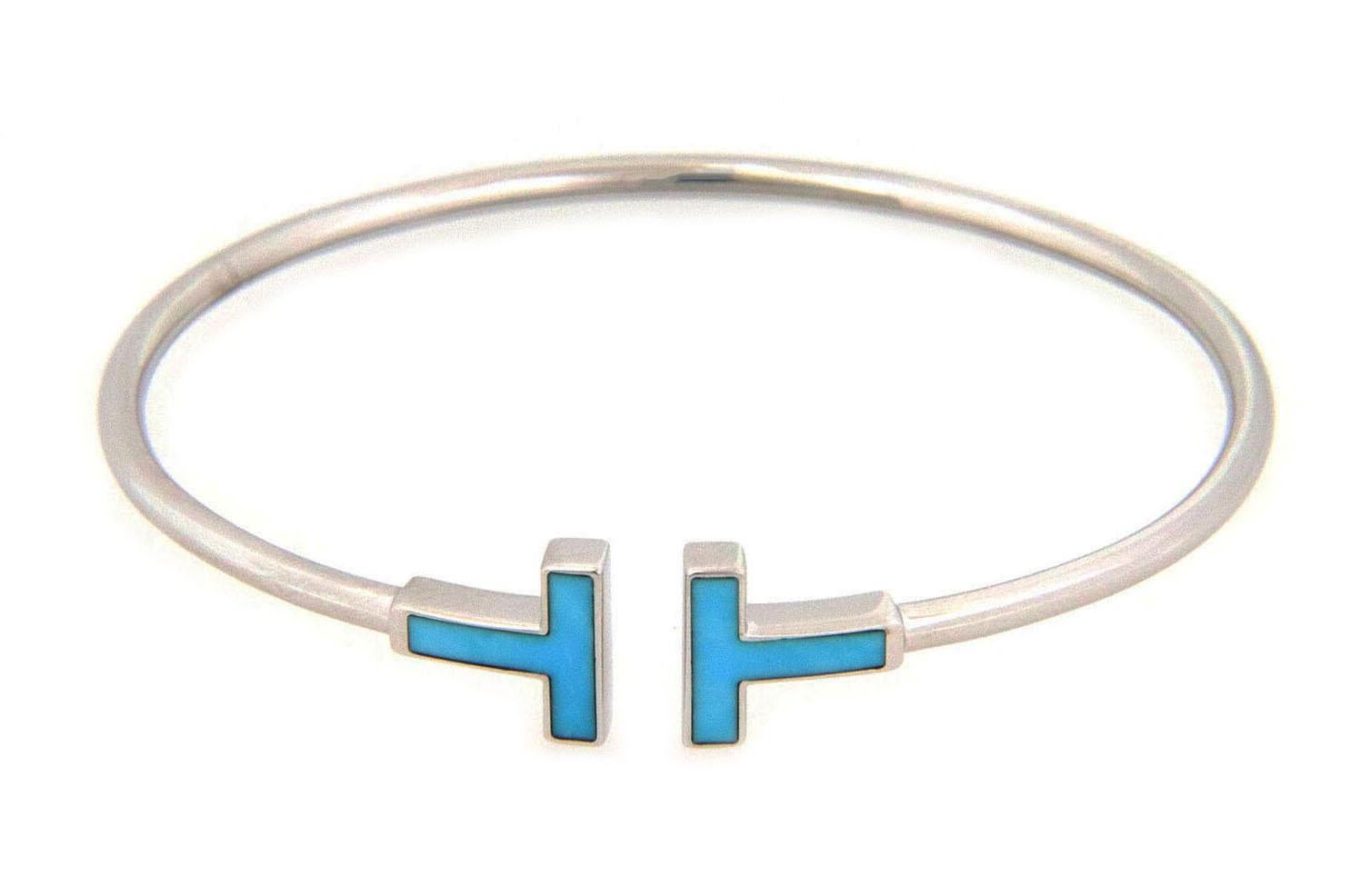 Tiffany T for Two, this charming and elegant authentic bracelet is by Tiffany & Co. from the Tiffany T Collection, it is crafted from 18k white gold with a fine polished finish, the band is in a 2mm thick wire style with the double end Ts inlaid