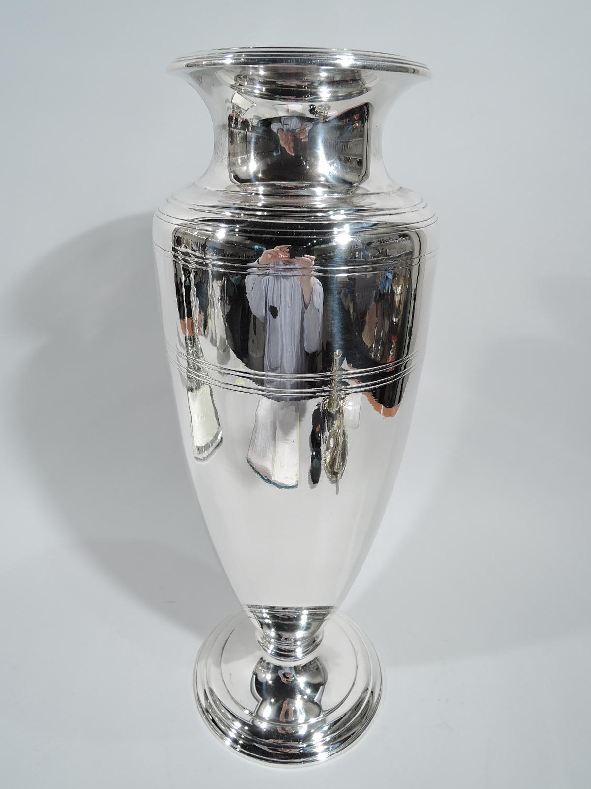 Tall Art Deco Classical sterling silver vase. Made by Tiffany & Co. in New York, circa 1927. Curved and tapering with spool neck and reeded rim, discreet base knop, and round stepped foot. Spare and graceful with tooled bands. Fully marked including