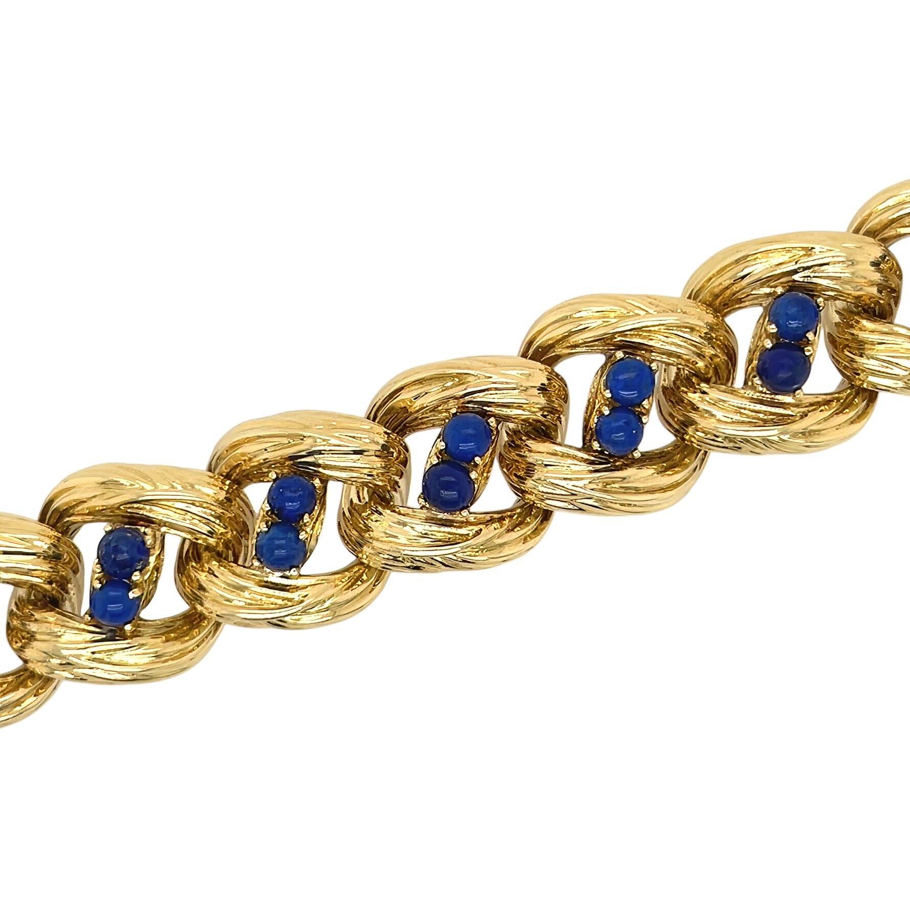 An 18 karat yellow gold and lapis lazuli bracelet, Tiffany & Co.  Designed as a length of bark textured and arced modified curb links, the center of each link displaying a bar set with two lapis lazuli beads measuring approximately 4.3 mm.  Length