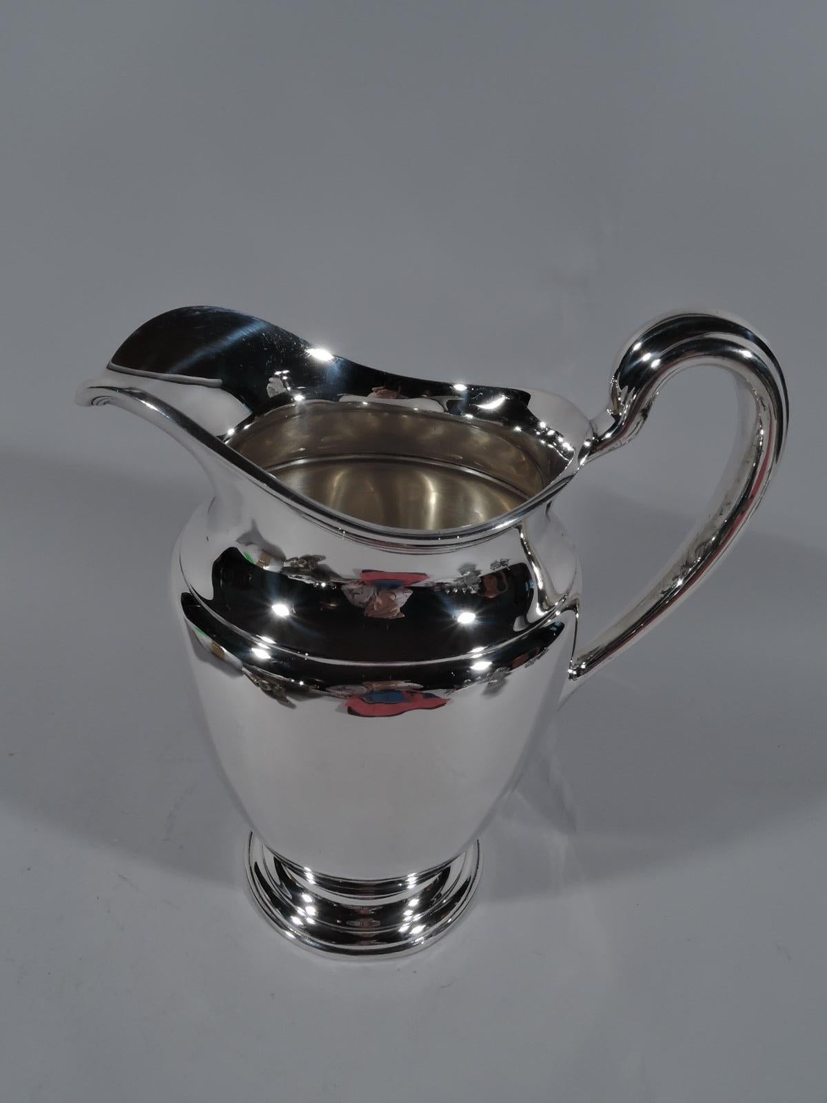 Traditional sterling silver water pitcher. Made by Tiffany & Co. in New York, circa 1938. Gently curved body with helmet mouth, high-looping handle, and round and stepped foot. Ample with nice heft. Fully marked including pattern no. 22625 (first