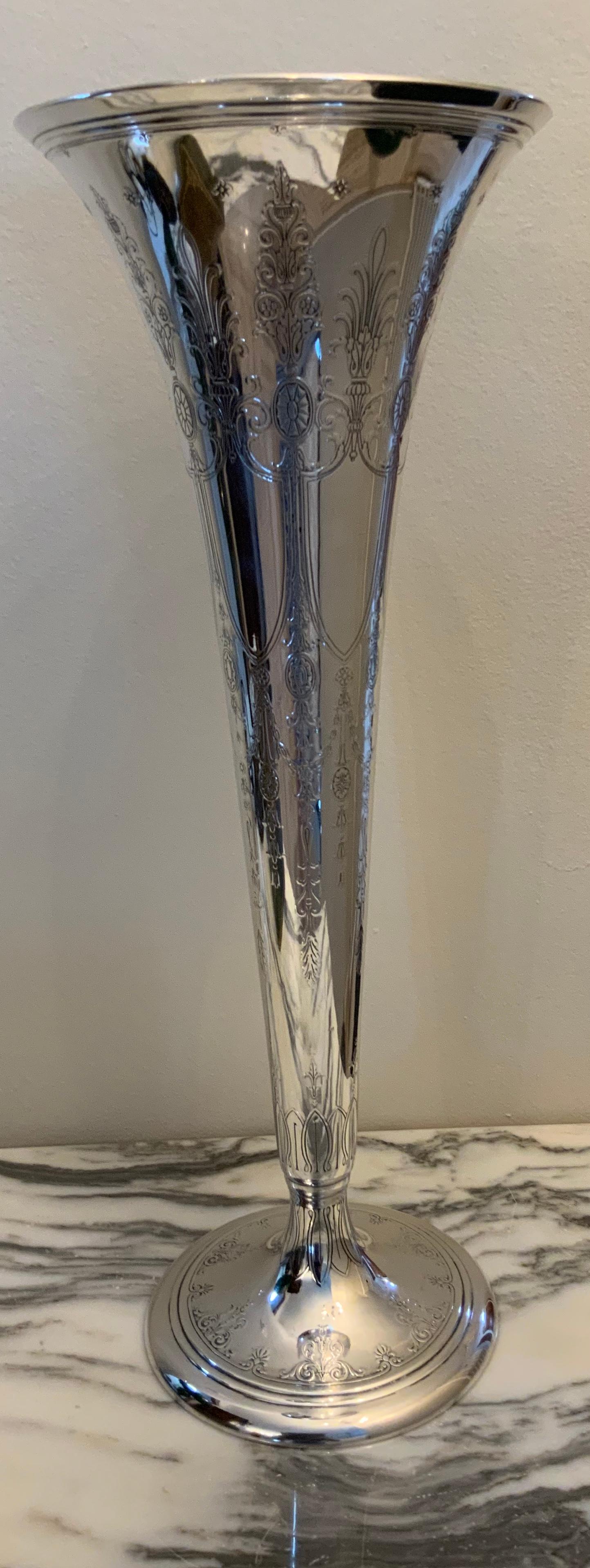 This sterling silver trumpet flower vase is etched with similar Adam style decor: swags, flowers, festoons, and palmettes. In its center it has a shield with the initials BCM and it is hallmark Ed Tiffany.