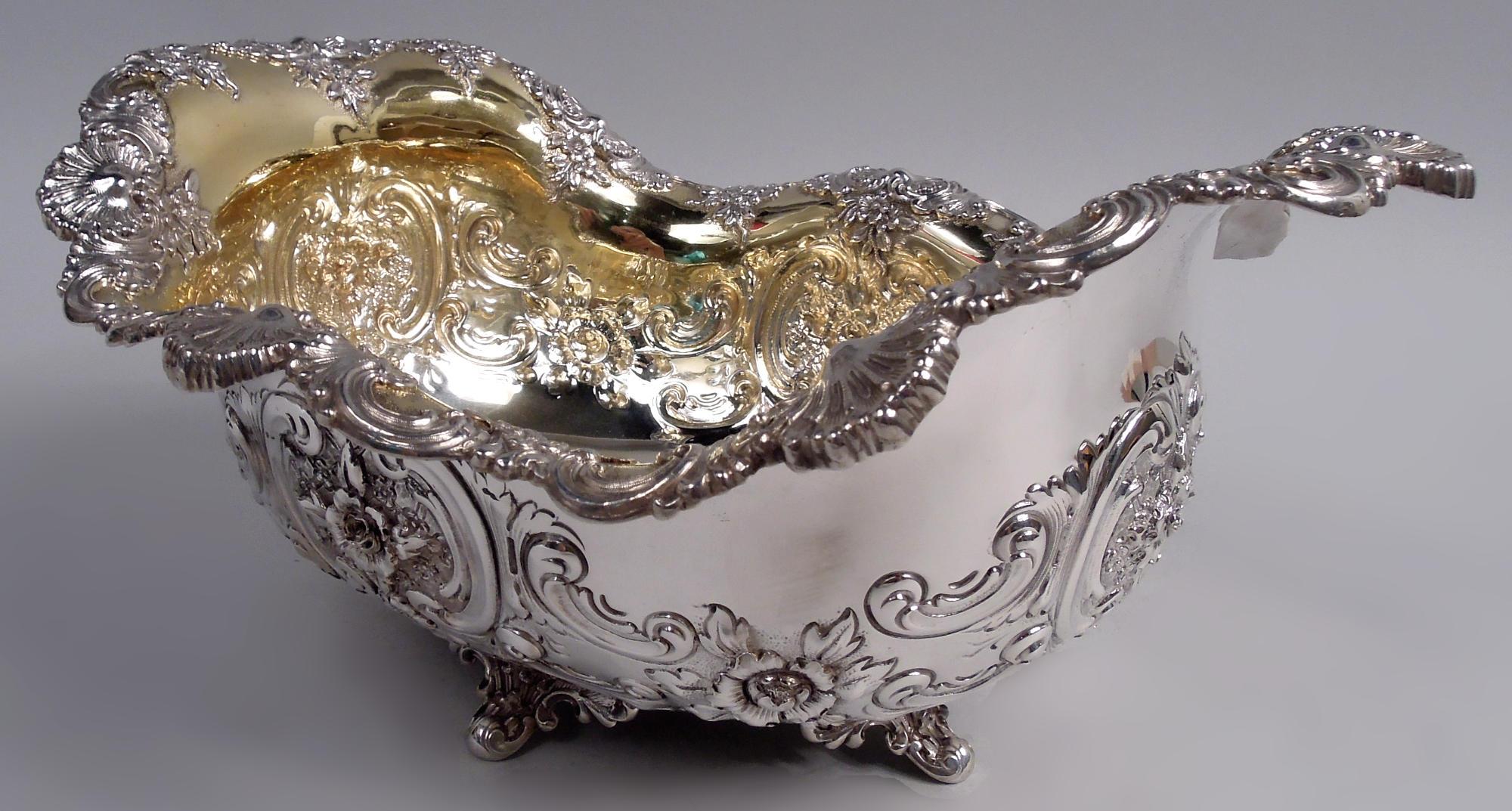 Victorian Classical sterling silver bowl. Made by Tiffany & Co. in New York, ca 1895. Curved and ovoid; rests on 4 leaf-mounted scroll supports. Wavy mouth rim with raised ends; cast scallop shells and scrolls with pendant flowers. Chased flowers