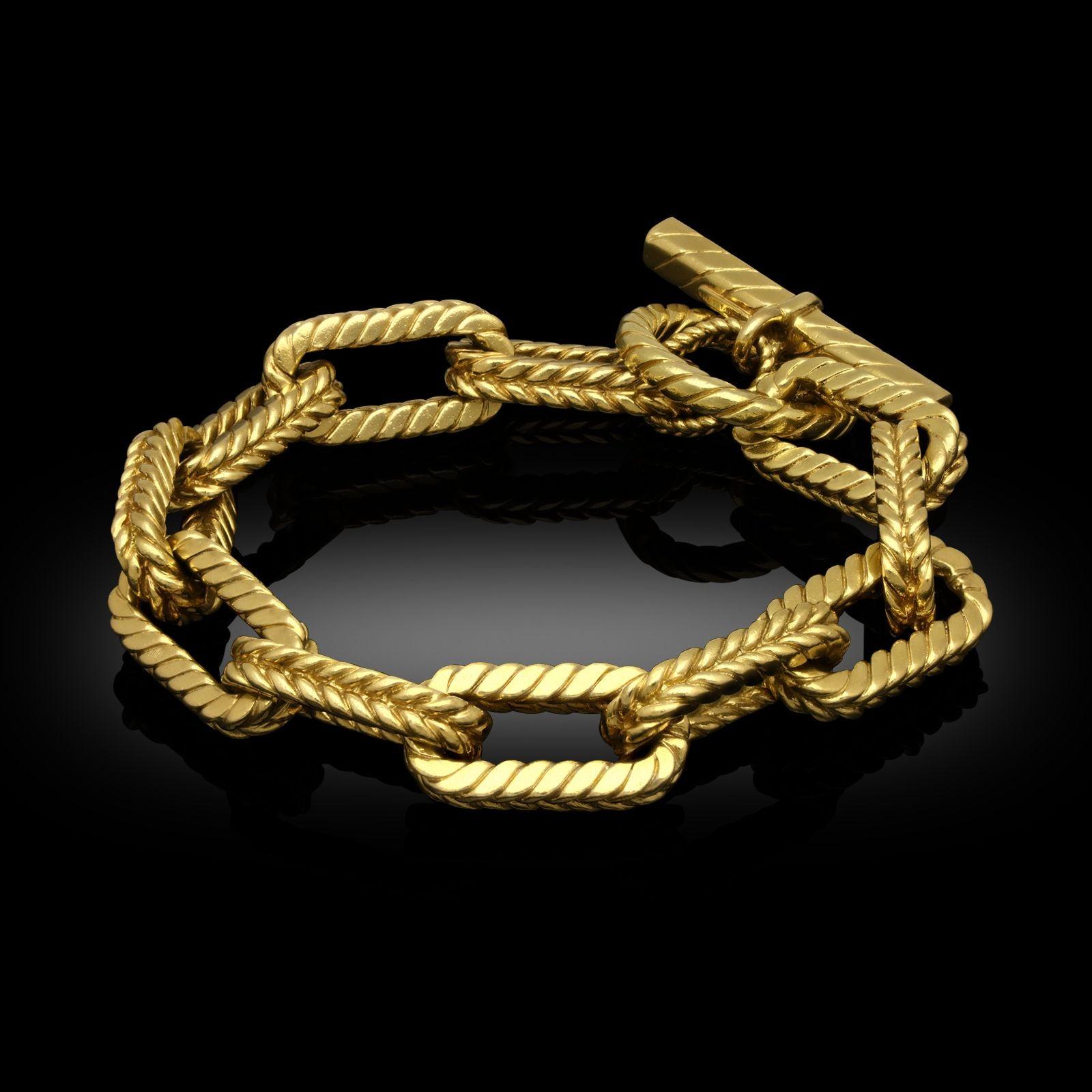 A vintage gold bracelet by Tiffany & Co. circa 1980s. The bracelet is designed as 18ct yellow gold rectangular anchor links (also known as the chaine d'ancre style.) Each link has a braided textured finish and is fastened with a loop and bar toggle