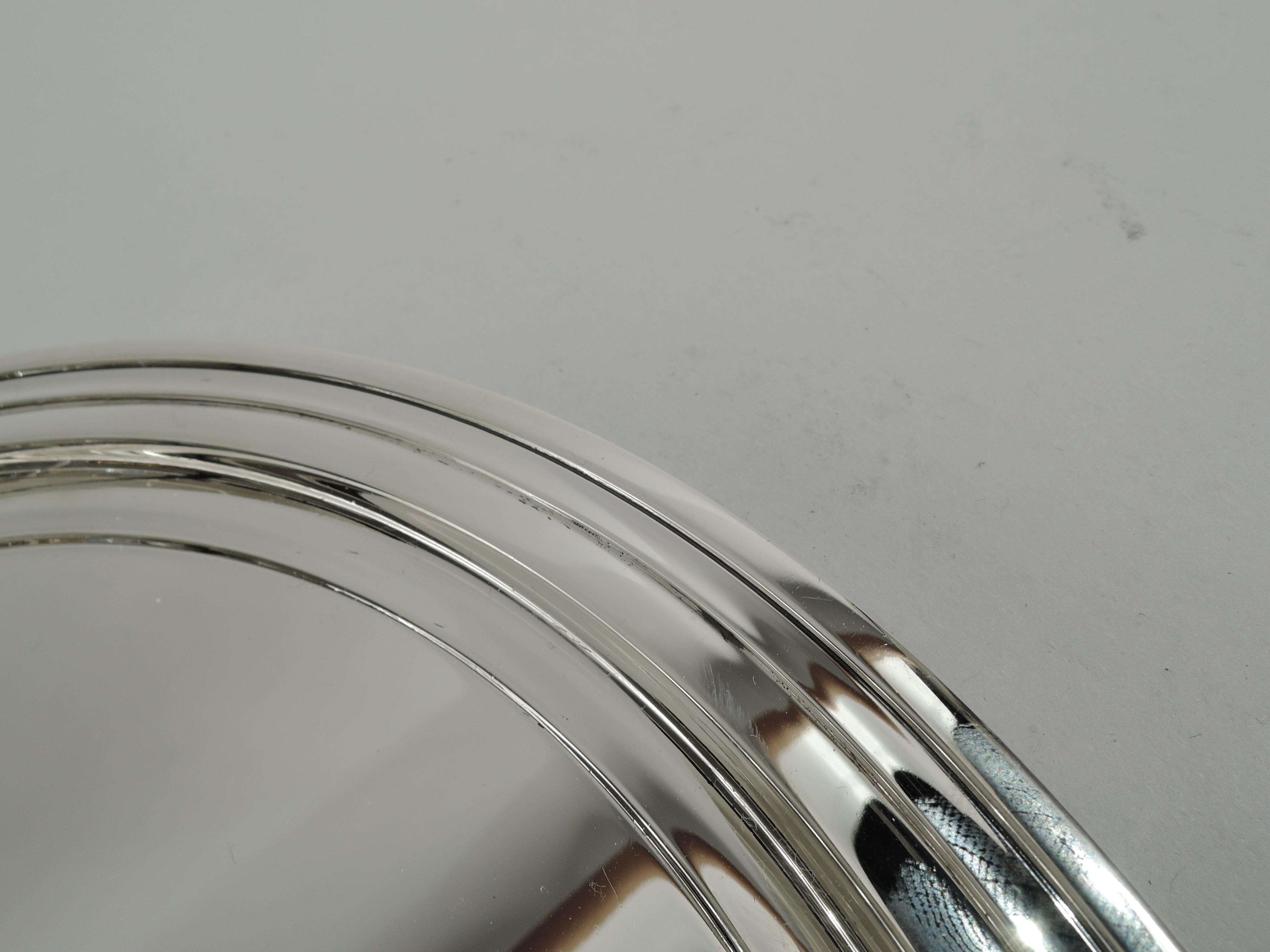Modern sterling silver serving tray. Made by Tiffany & Co. in New York. Round with stepped rim. Smart and functional with nice heft. Fully marked including maker’s stamp, pattern no. 21252, director’s letter m (1907-47), and wartime star (1943-5).