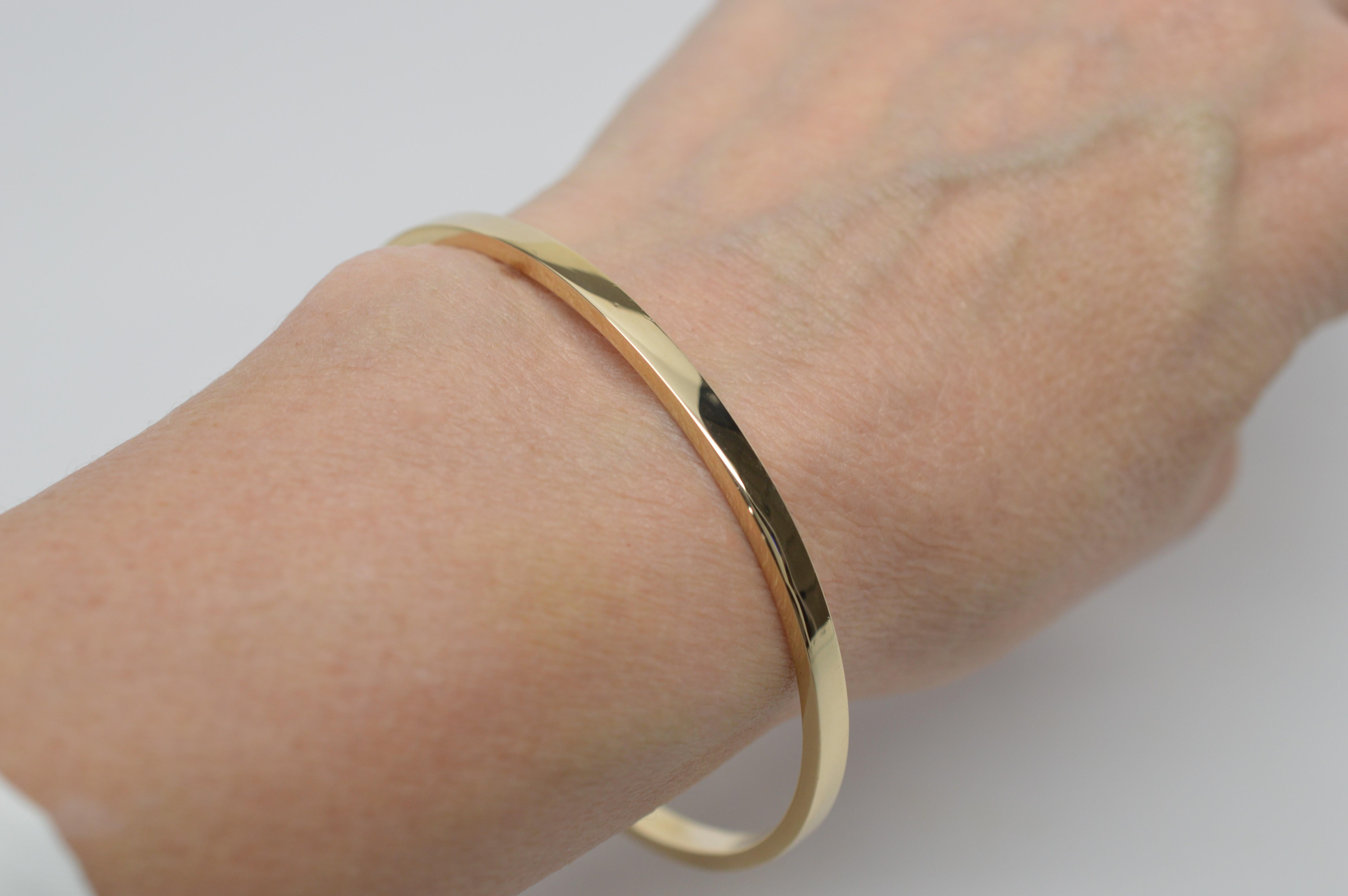 Tiffany signed 14 Karat Yellow Gold Bangle Bracelet. Slim and sleek, measuring 2-3/4 inch diameter and a 7-1/2 inch circumference.
Nearly new with a bright, polished finish. Slide-on style.  From the Estate Collection. In gift box. 