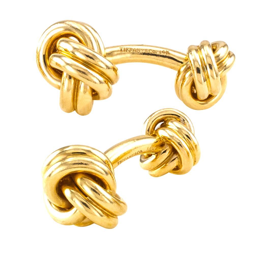 Tiffany & Co gold knot cufflinks circa 1970s. The faces and backs designed as knots with a bar connector, crafted in 14-karat yellow gold, signed Tiffany & Co. Very pristine condition consistent with age and wear. What is it we like about these