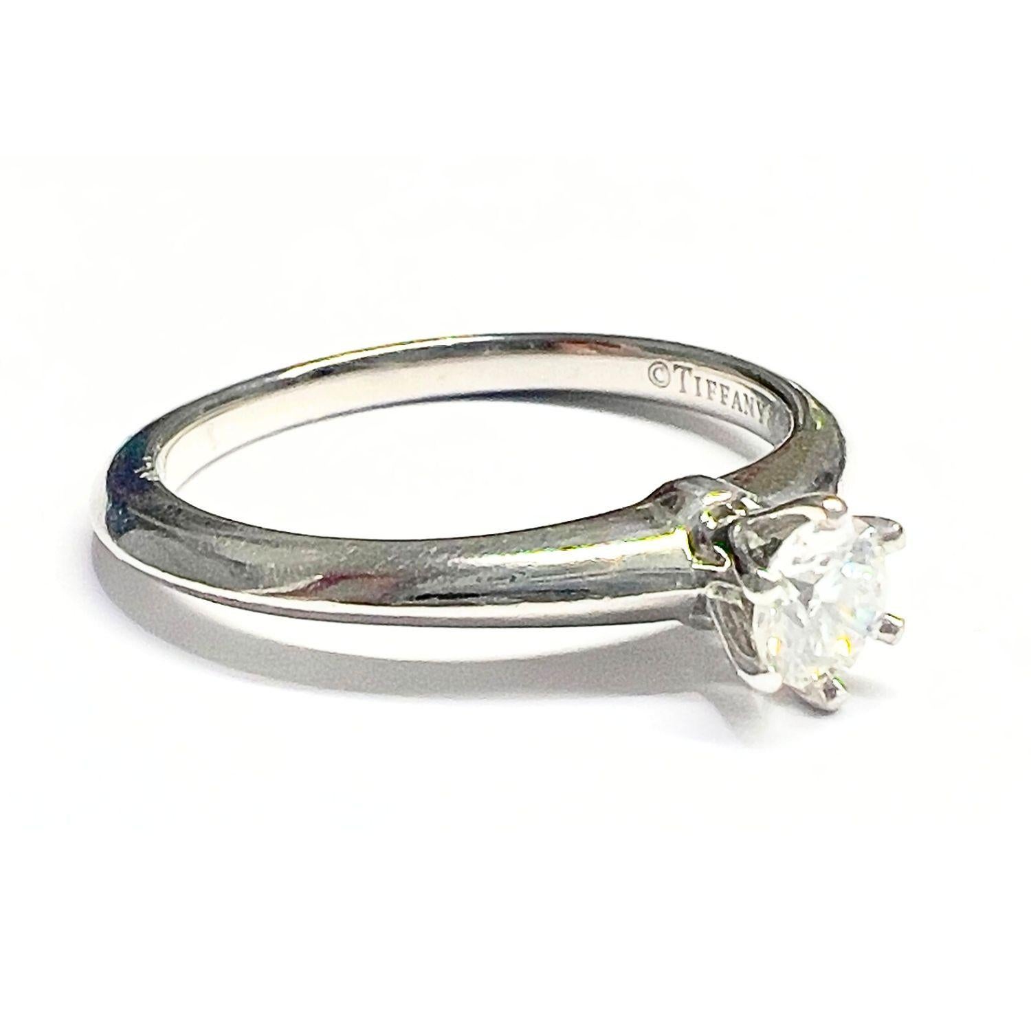 This exquisite set features a contemporary design by Tiffany&Co., showcasing a stunning solitaire ring and matching band. 
Crafted from luxurious 950kts platinum, the Solitaire Engagement Ring size is 12,5/52,2, the center stone is a Natural Round