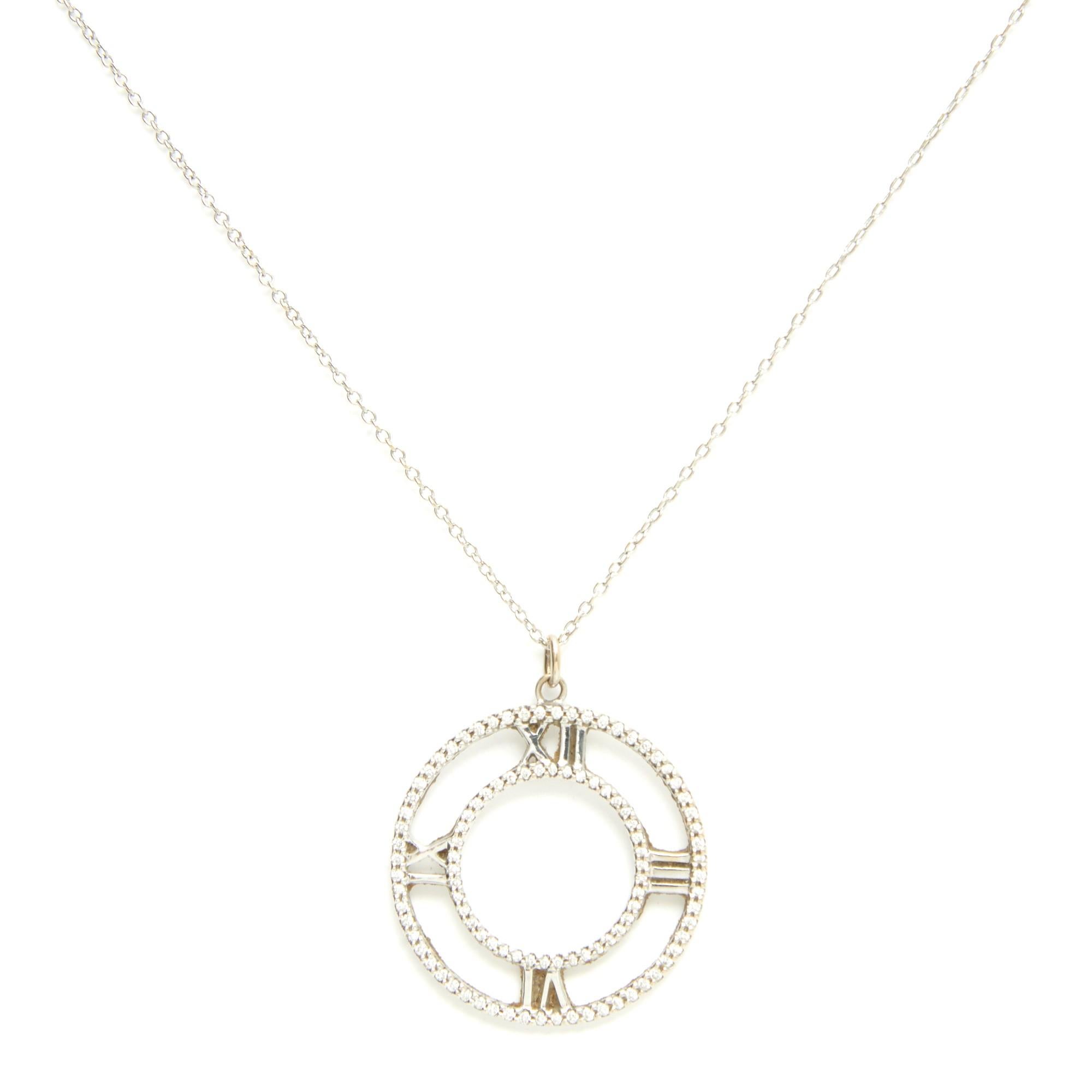Collier modèle Atlas de Tiffany & Co en or blanc 18 carats, composé d'une chaîne et d'un pendentif de petite taille incrusté de diamants taillés en brillant. Longueur du collier ouvert 59,7 cm, diamètre du pendentif 2,9 cm, poids des brillants 0,14