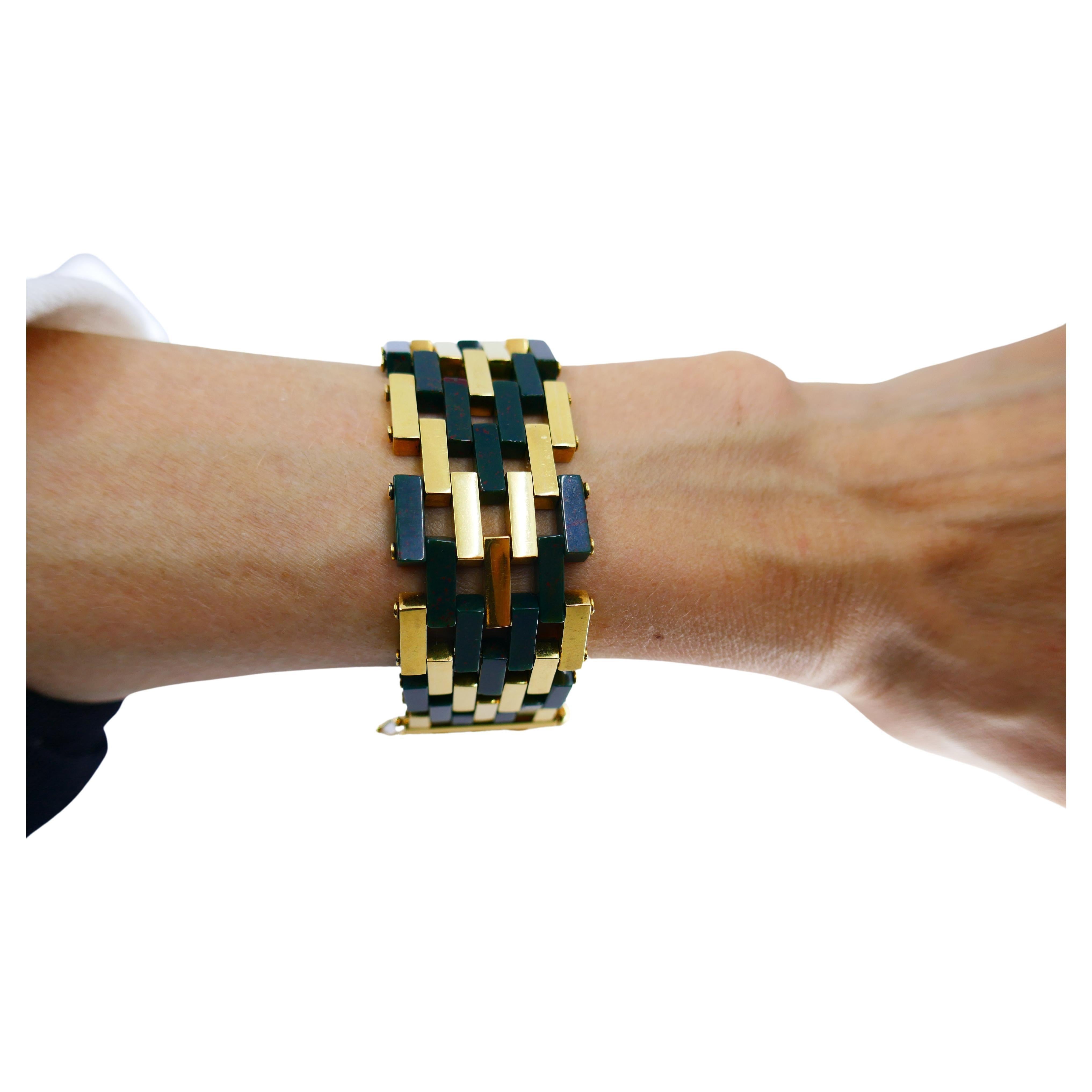 A unique vintage (circa late 1960s) Tiffany & Co. bracelet made of 18k gold and bloodstone. 
The bracelet crafted with a herringbone pattern, where the bloodstone planks alternated with the gold ones. The bracelet is flat and perfectly sits on a