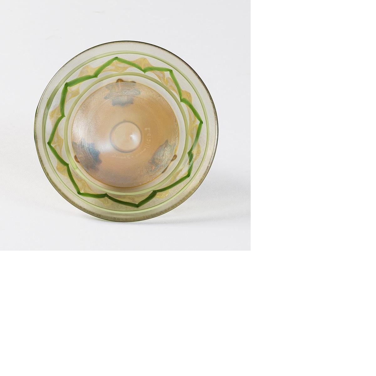 A Tiffany Studios New York Favrile glass bowl with Byzantine decoration by Louis Comfort Tiffany. 
 
This delicate translucent bowl is decorated in the colors of silver, gold and green. It sits on three gold-colored scroll-shaped glass feet, circa