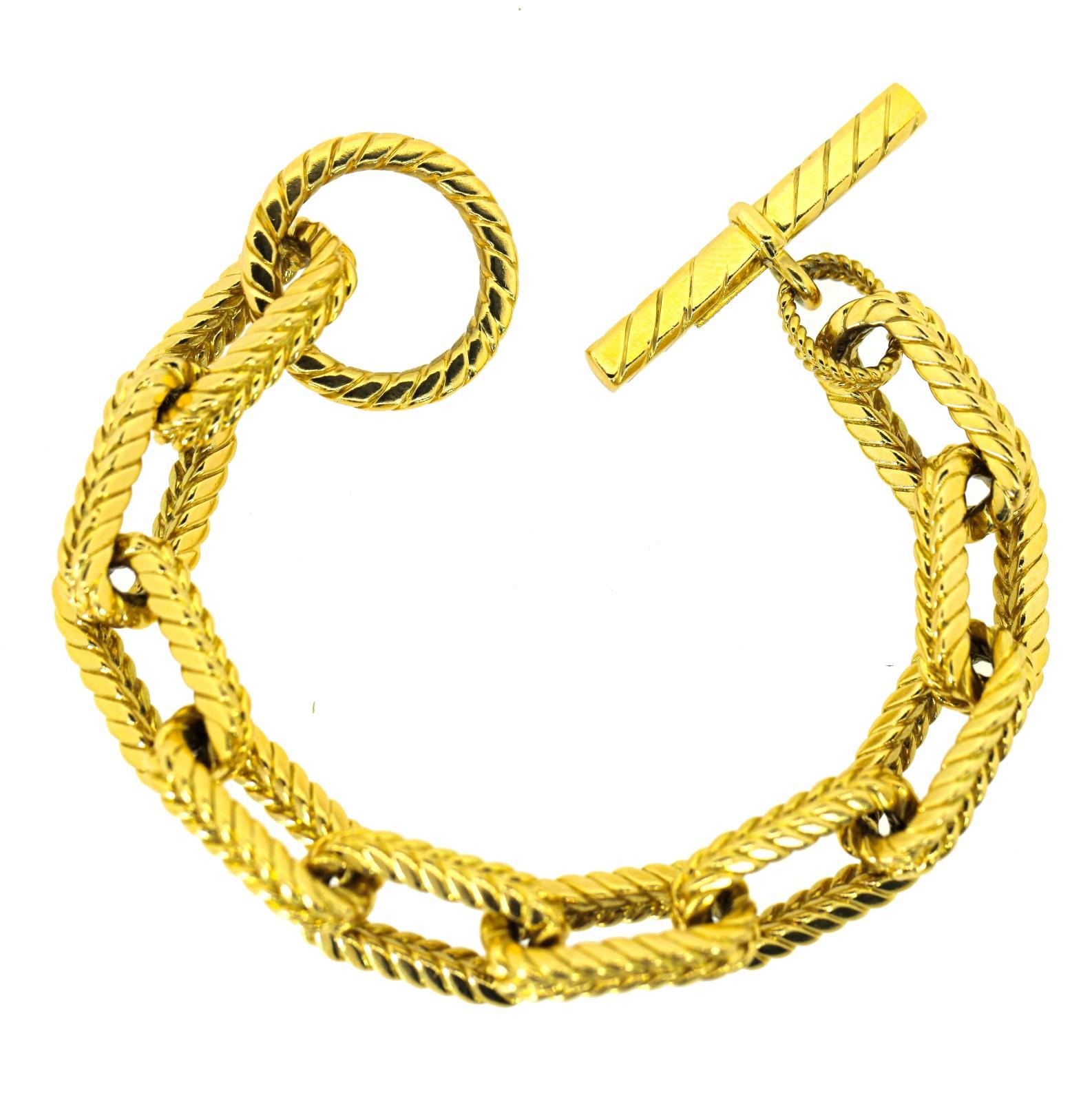 An impressive 18KT yellow gold Tifffany & Co. link bracelet.  This practical bauble is comprised of oval squared rope like links completed wit a loop and T-bar closure.  It weighs a hefty 115 grams and is 7.5 inch long, stamped 