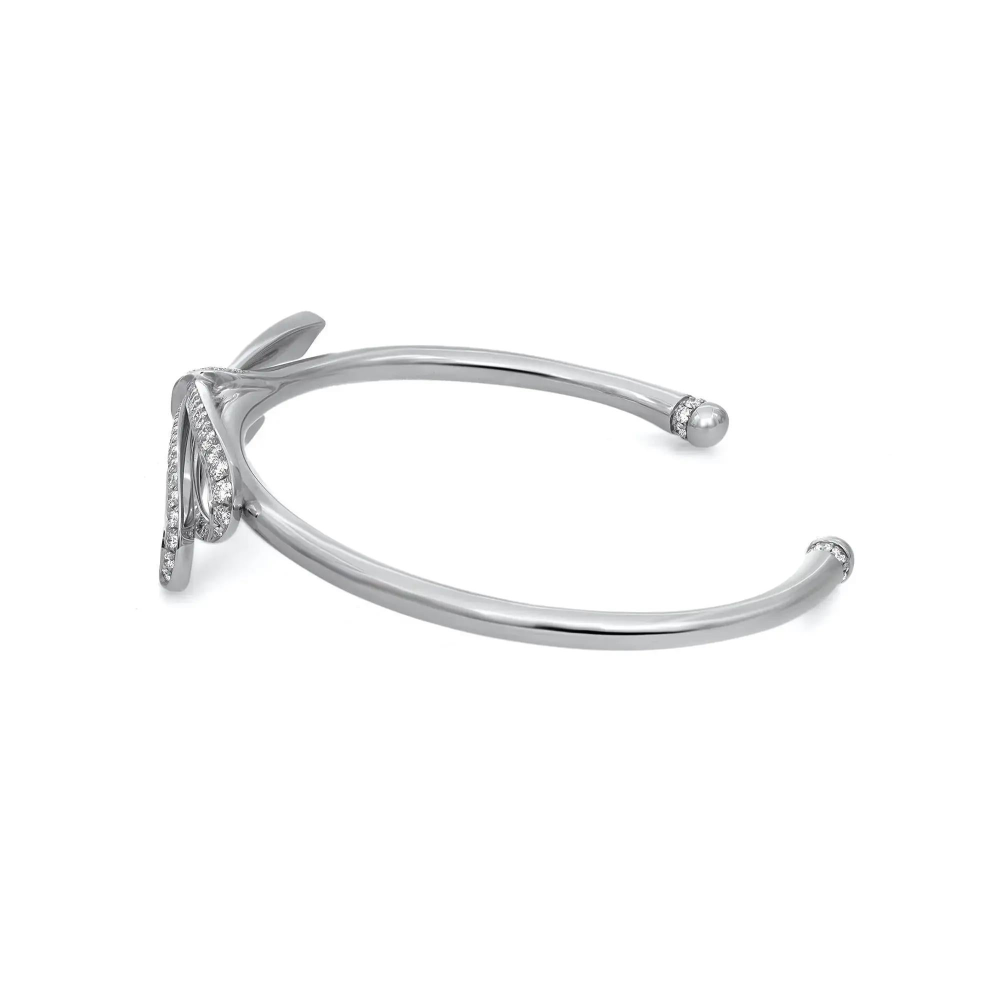 Cette magnifique pièce de Tiffiany & Co. Le bracelet manchette à gros nœud en diamant exsude la sophistication. Whiting en or blanc lustré 18K. Il s'agit d'un bracelet manchette avec un grand nœud au centre, serti de diamants ronds de taille