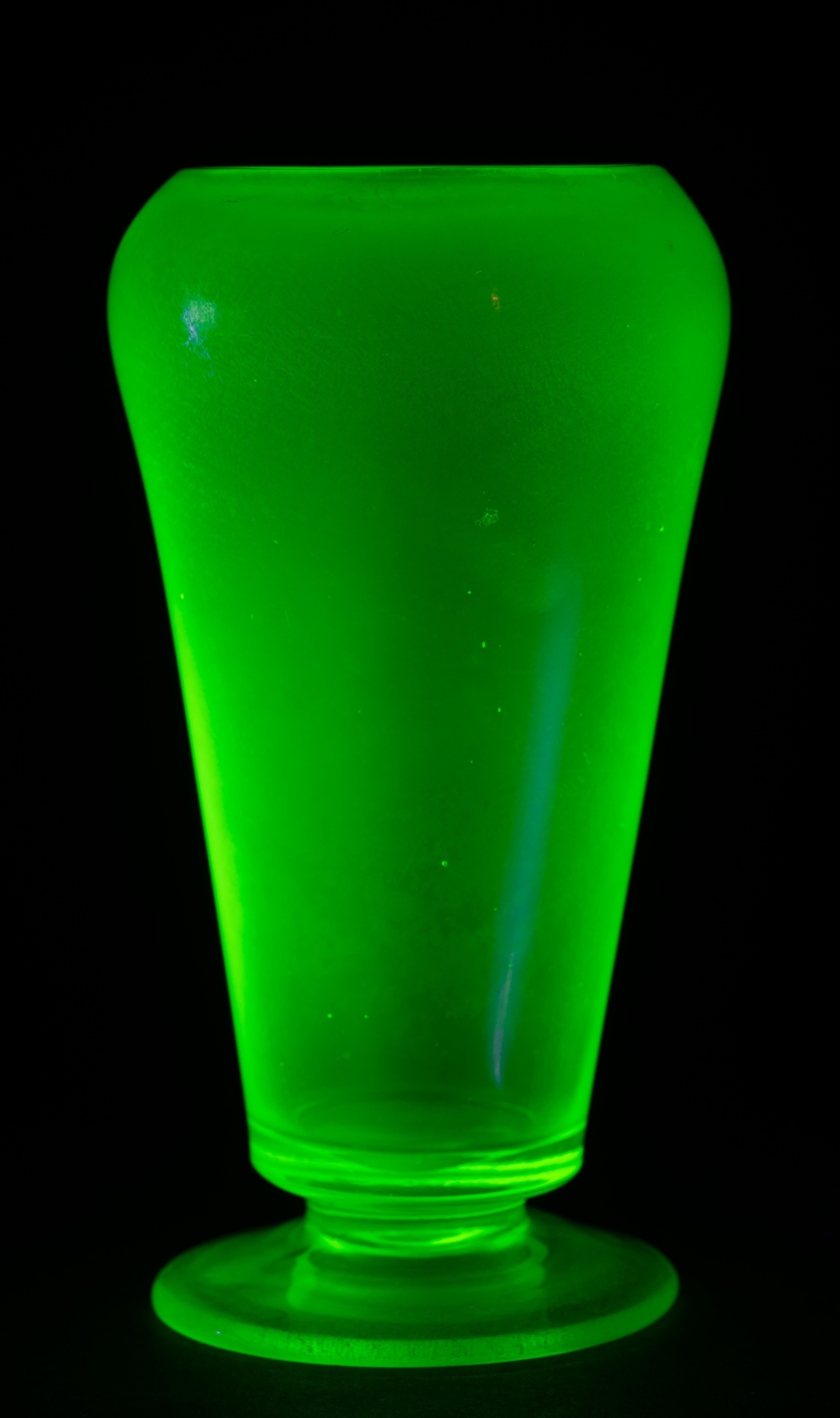 Sculptural Art Deco style vase is made of uranium green glass. Minimal, streamlined shape and color scheme of the piece are accentuated with iridized finish, that adds visual interest without taking attention away from the graphic, monumental