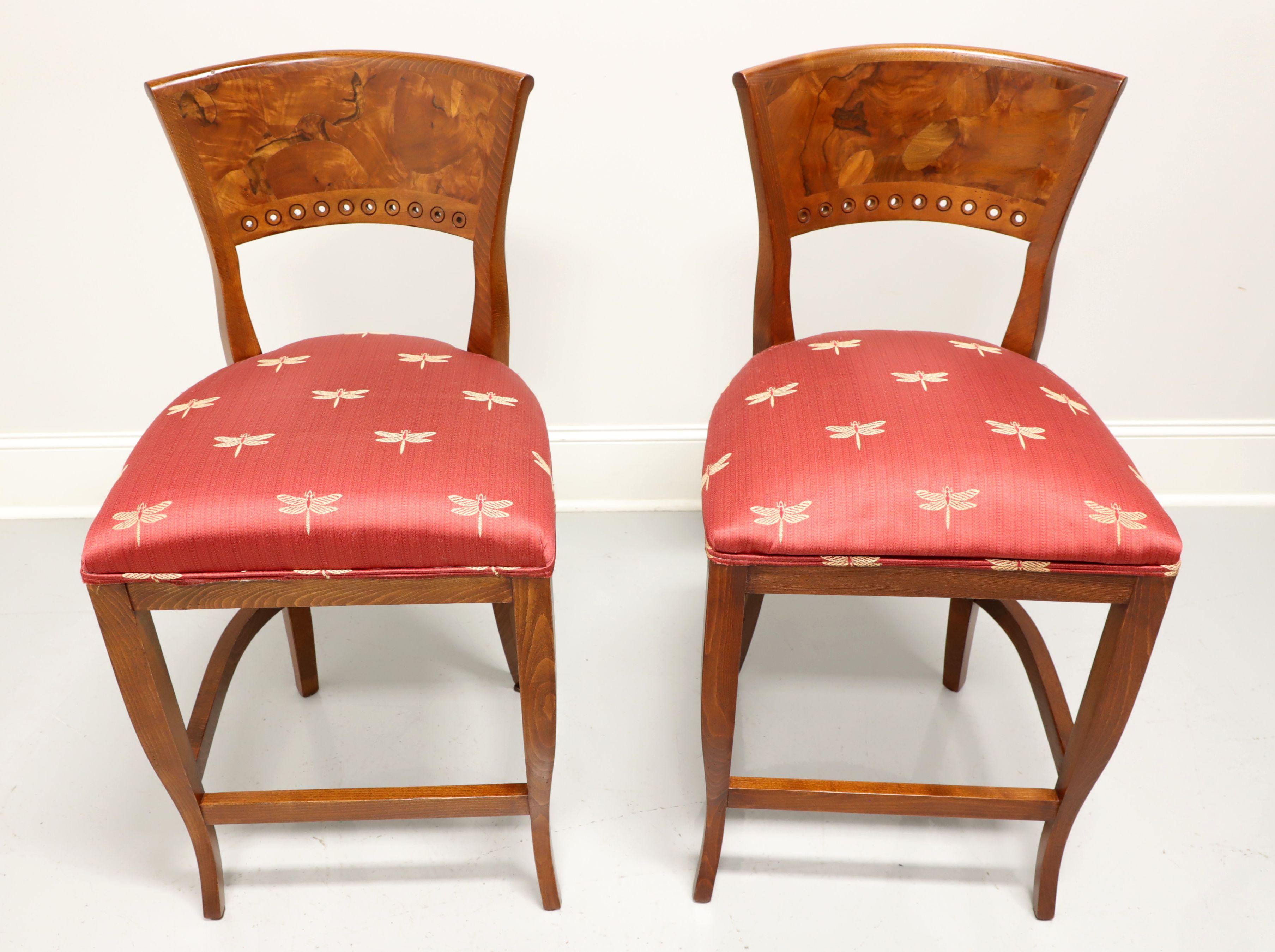 A pair of Neoclassical style counter height stools by Emerson et Cie, of High Point, North Carolina, USA. Tiger & burl oak backrests, salmon colored fabric with gold fireflys upholstered seats, saber legs with curved stretchers and footrest. Made in