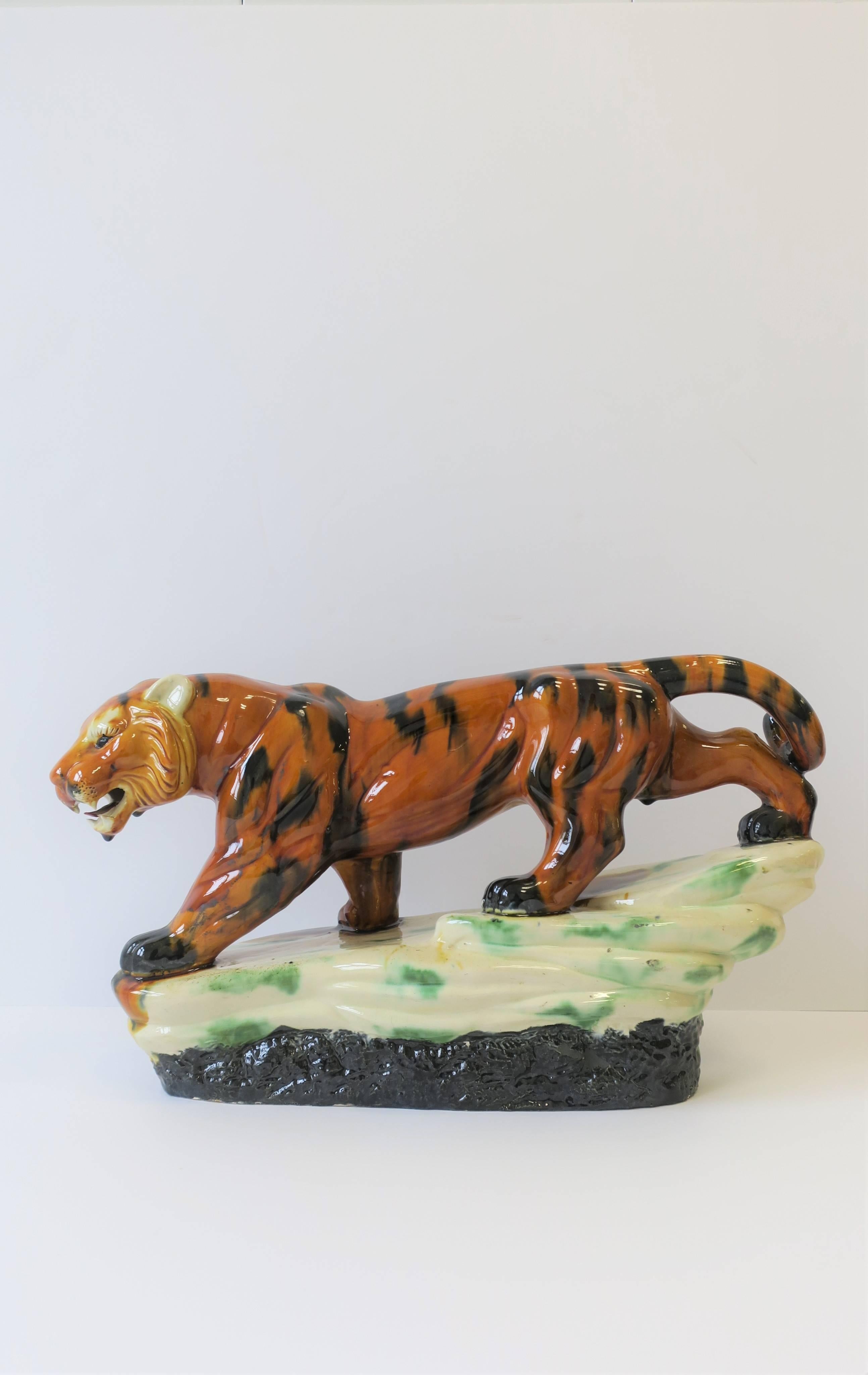 A relatively large ceramic tiger cat animal sculpture piece decorative object in the Art Deco style, circa mid to late-20th century. Beautiful detail in face, mouth, body/muscle structure and tail. Piece is made by hand as reads on bottom, shown in