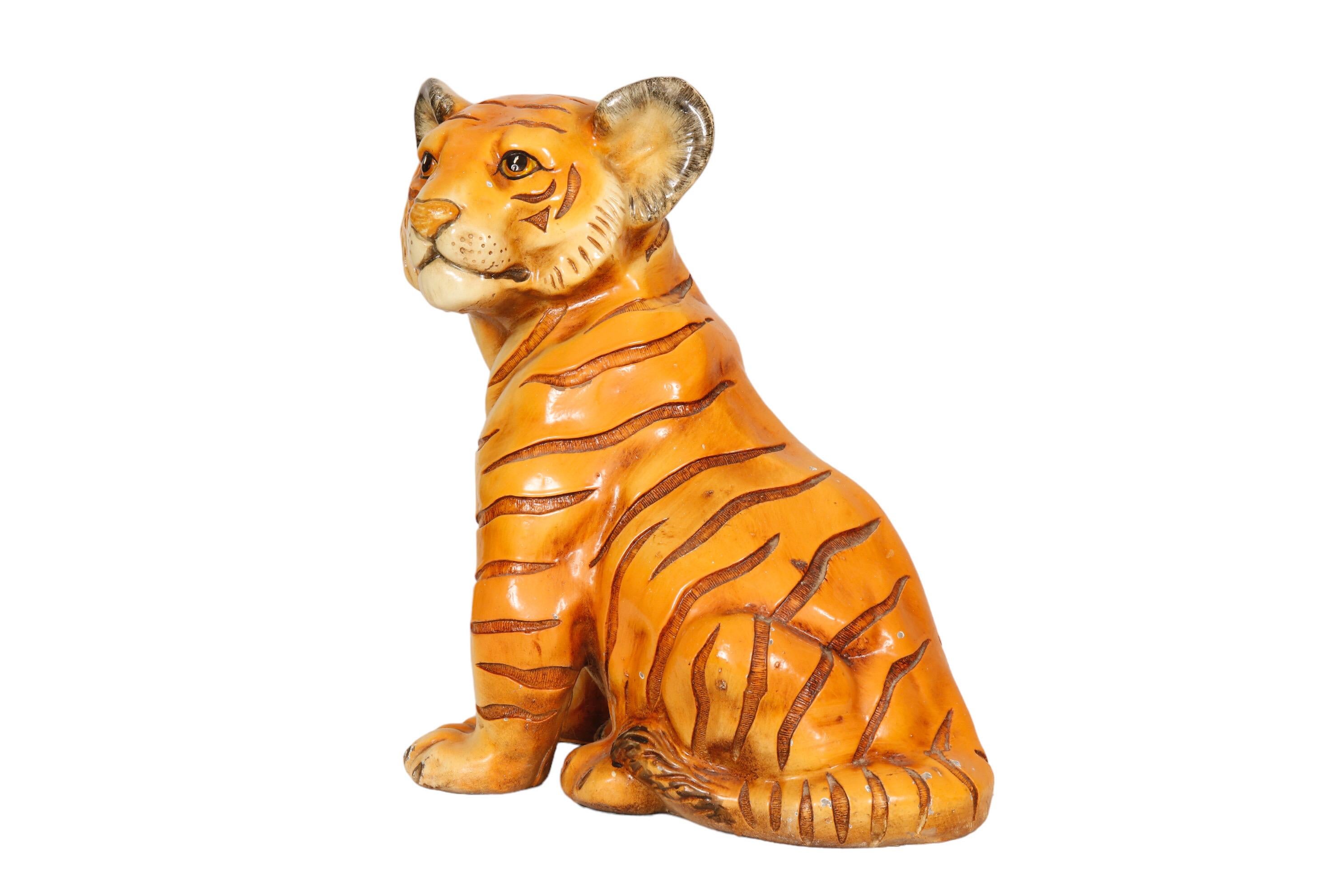 A large gypsum sculpture of a tiger cub. Cast in a life-like manner with embossed details on the stripes, the face and paws. Hand painted with fine lines around the eyes, ears, nose and mouth. Marwal Industries Inc. maker's mark is visible in the