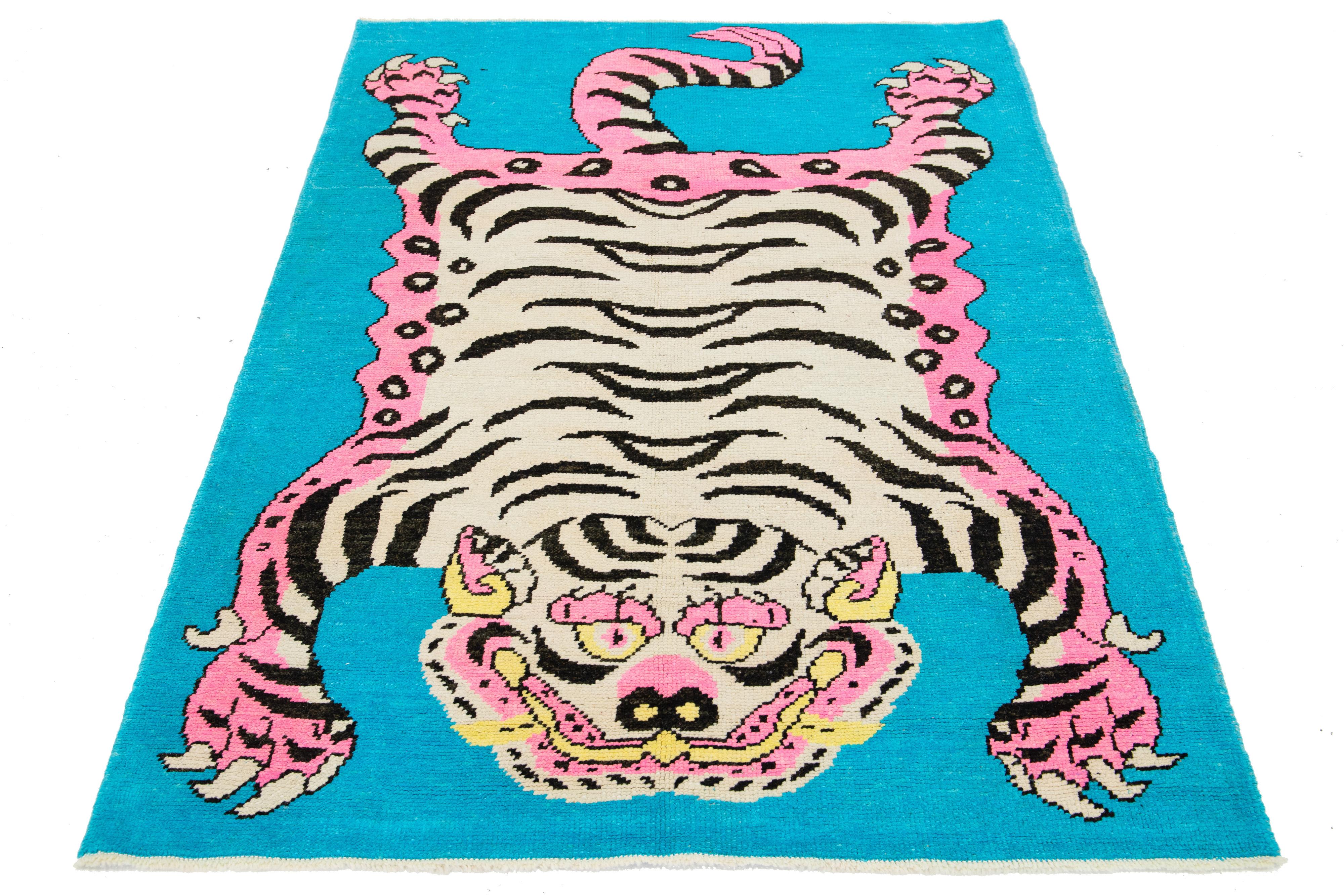 This Turkish Art Deco wool rug features a beautiful tiger pictorial design with a blue field and pink and beige accent colors, all handmade with care.

This rug measures 4'9