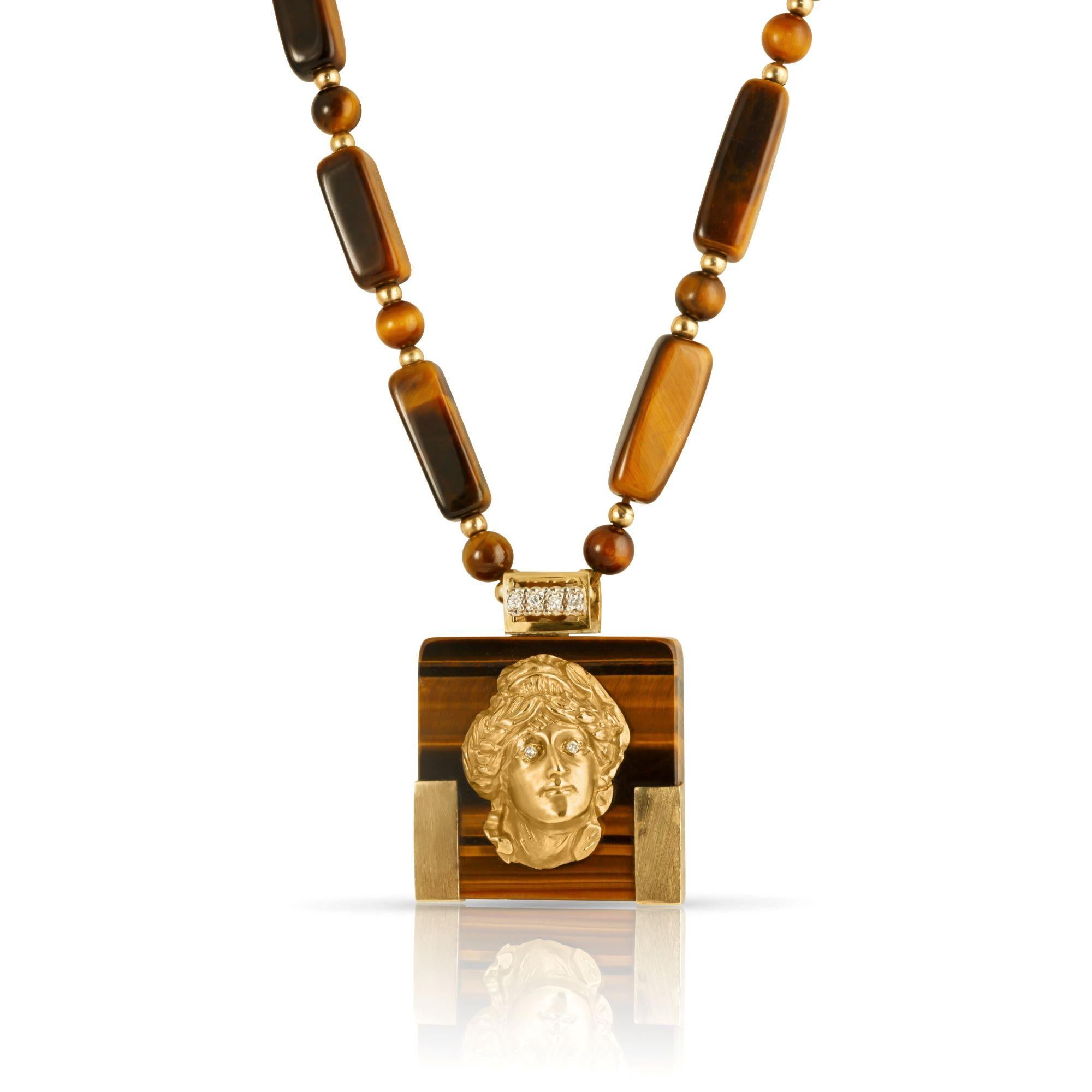 A magnificent and substantial tiger eye necklace with a dreamy portrait pendant from the heart of the 1980s. Long and significant, the necklace is composed of 23 multi-dimensional tiger eye stones in irregular rectangular shapes, intersected by