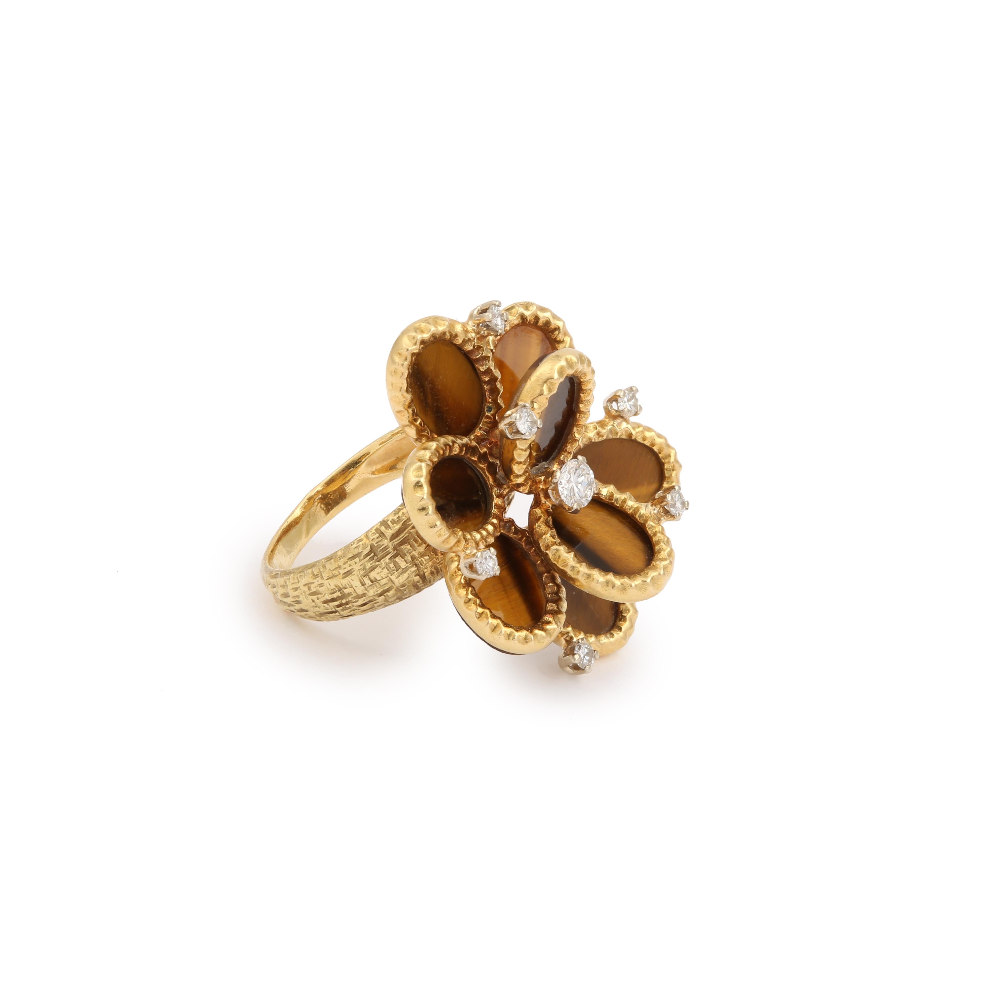 Surprising vintage ring featuring a yellow gold flower set with tiger eye cabochons for the petals and small round diamonds.

This model of ring was probably created by the company Edouard Richards (52 rue Lafayette), which essentially worked for