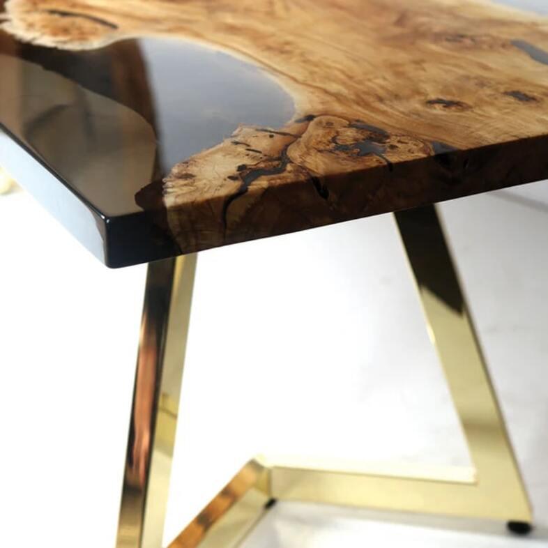 Wir stellen Ihnen unseren Tiger Eye Couchtisch vor, ein wahres Kunstwerk, das jeden Wohnbereich aufwertet. Aus hochwertigem Holz und halbtransparentem schwarzem Epoxidharz gefertigt, bietet dieser Tisch eine faszinierende Mischung aus Farben und