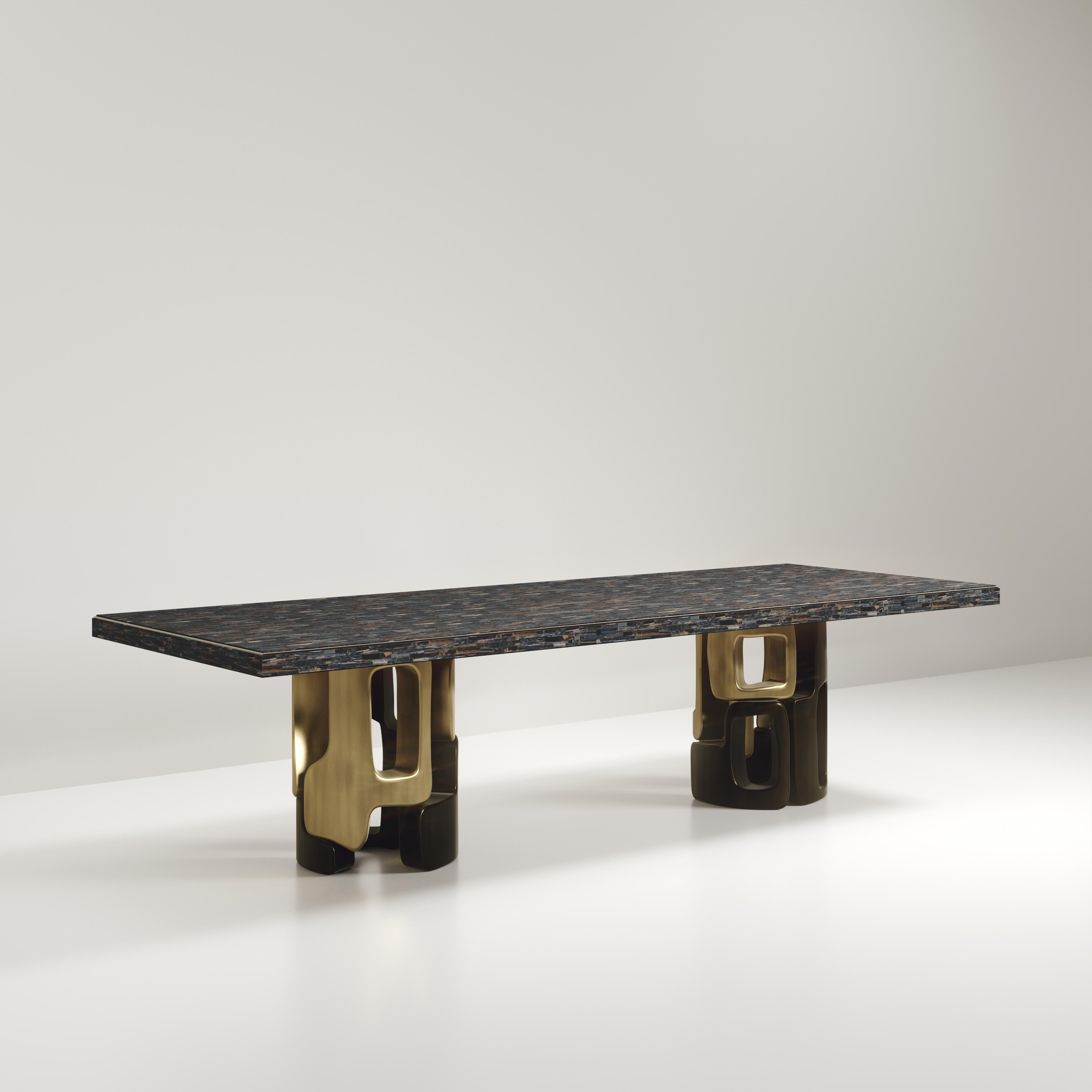 The Apoli I Dining table by Kifu Paris is both dramatic and organic in its unique design. The stunning semi-precious Tiger Eye Blue top sits on a pair of geometric and sculptural bronze-patina brass bases. This piece is designed by Kifu Augousti the