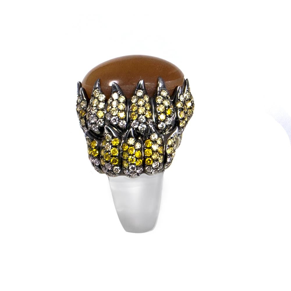 This stylish Tiger's Eye ring features a 15.75 carat natural cabochon Tiger's Eye stone with 2.75 carats of fancy colored genuine diamonds set in 18 karat white gold. The ring is in size 7 and if needed it can be resized. It has a natural luster of