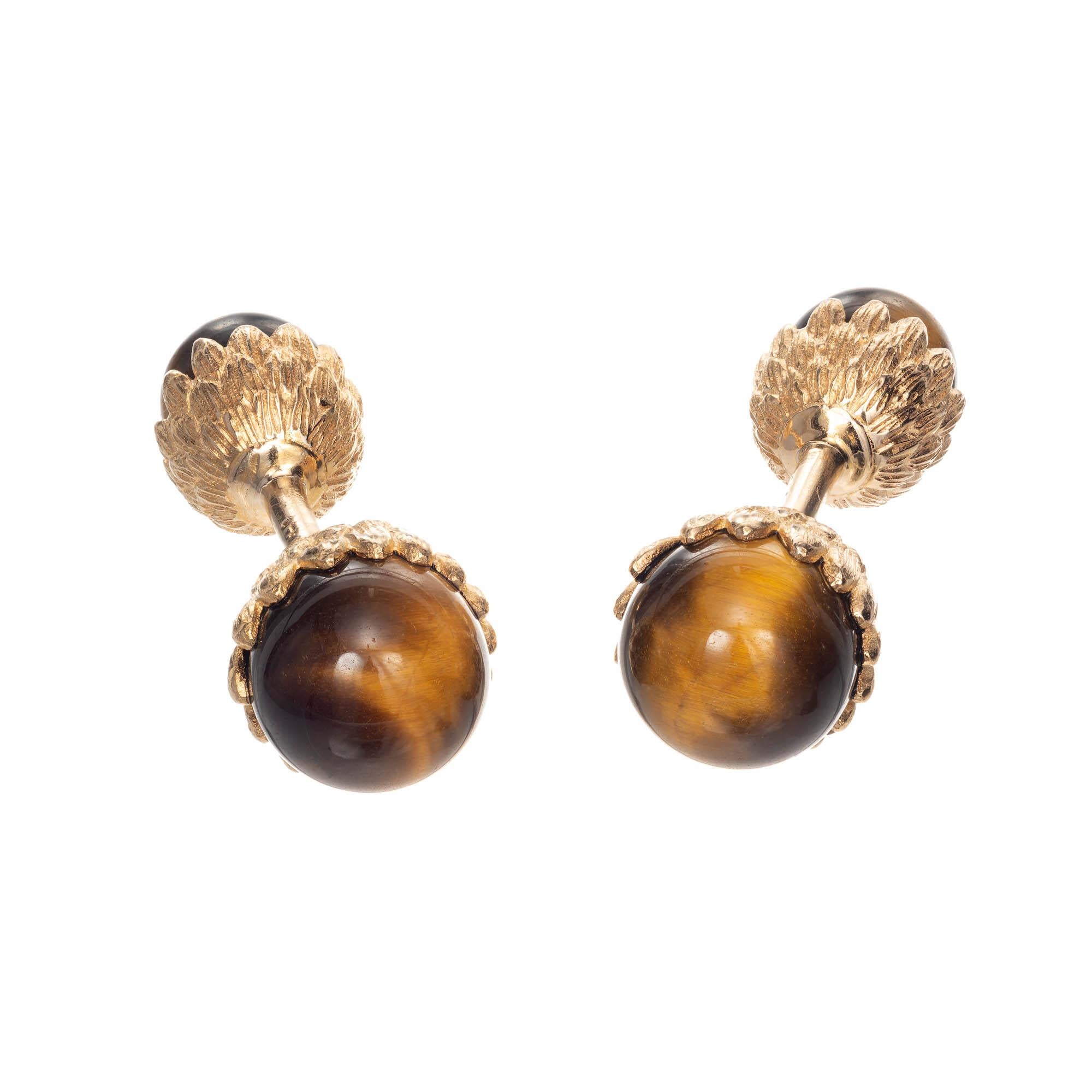 14k yellow gold Tiger Eye cuff links. A larger and smaller round Tiger’s Eye is set in 14k yellow gold majestic style setting.

2 brown & yellow Tiger’s Eye bead, 10mm 
2 brown & yellow Tiger’s Eye bead, 8mm 
14k yellow gold 
Tested and stamped: 14k