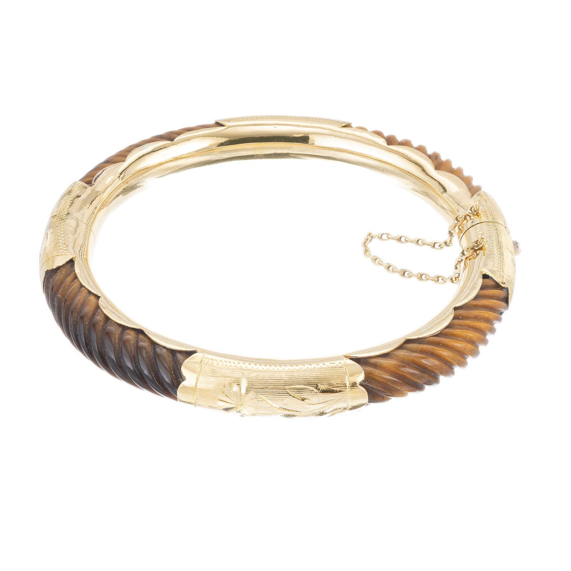 1960's Four section curved tiger eye and 14k yellow gold hand engraved bangle bracelet with safety chain. Circa 1960.  7-7.5 Length.  

Diagonally corrugated tigers eye
14k yellow gold
Stamped: 585 14k
25.3 grams
Width: 8.0mm 
Thickness/depth: