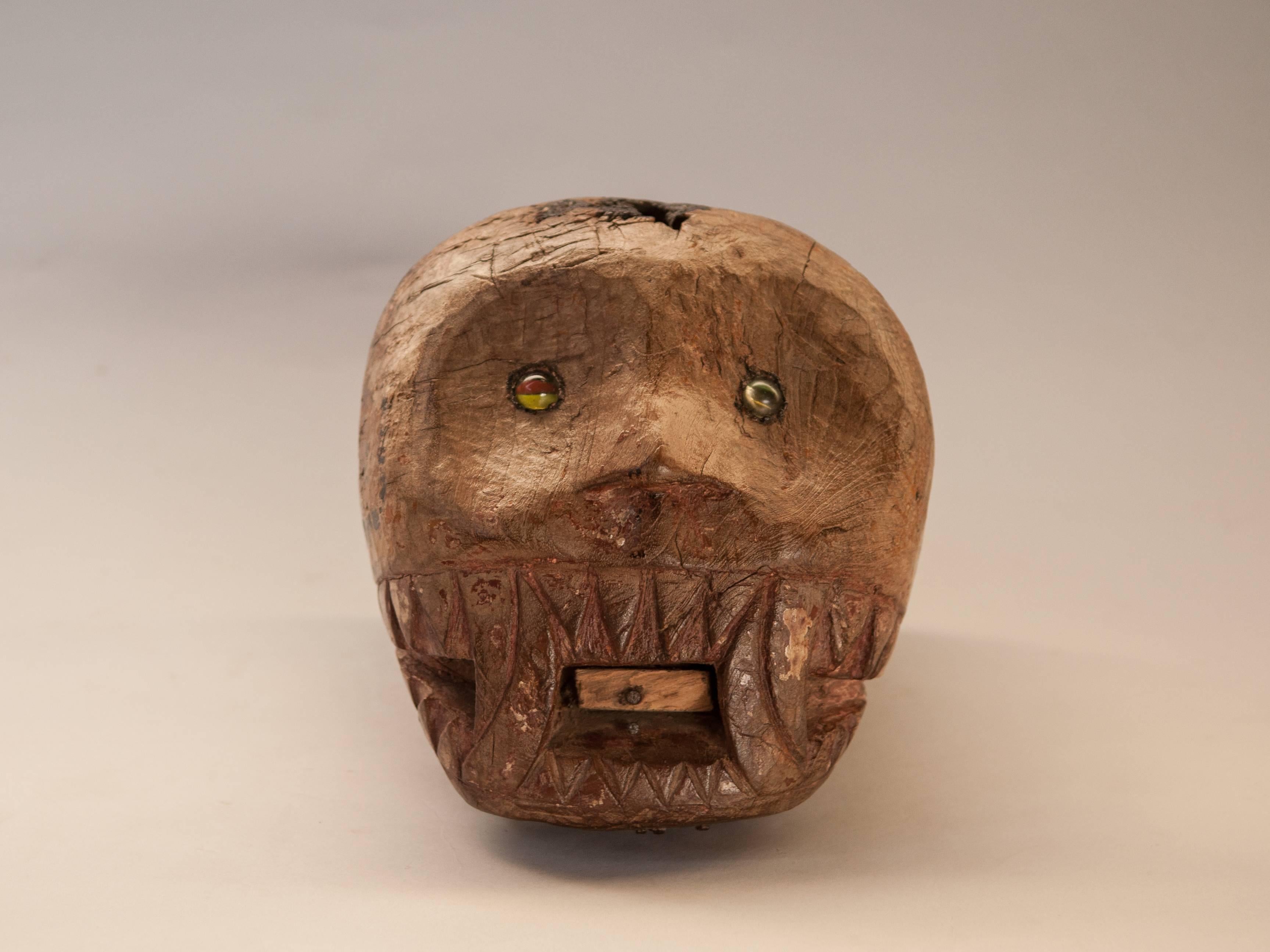 Tiger head carving with glass eyes from East Java, teak, mid-20th century.
Rustic carving of the head of a tiger. Remnants of paint are visible. The ears and the projection of the tongue are missing, but the penetrating glass eyed gaze remains.
