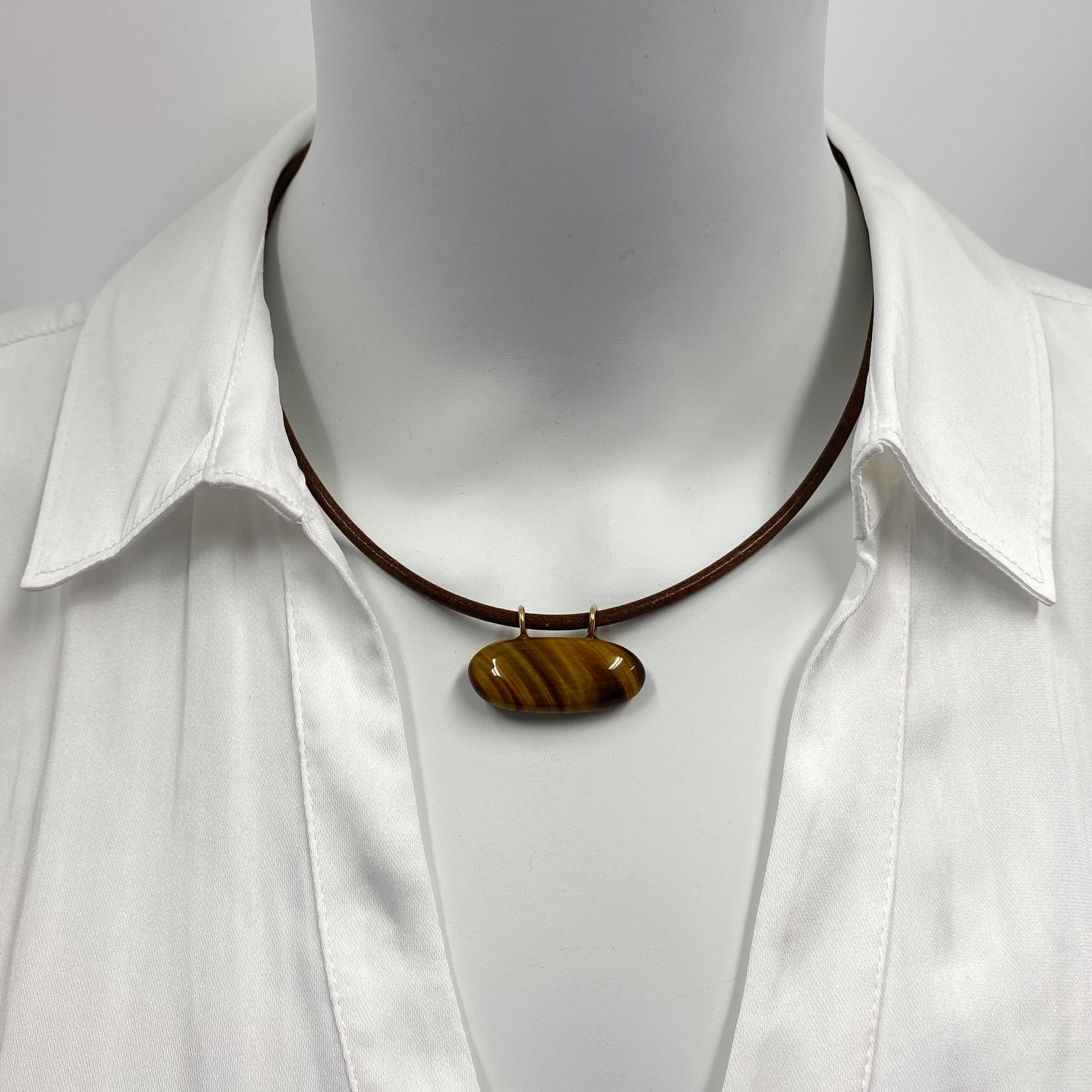 Eytan made this tumbled baguette*-shaped tigers eye quartz -- with plenty of its distinctive shimmer and play -- into a slick little pendant by the simple expedient of drilling a couple of loops into the top!  Feels great against the skin and makes