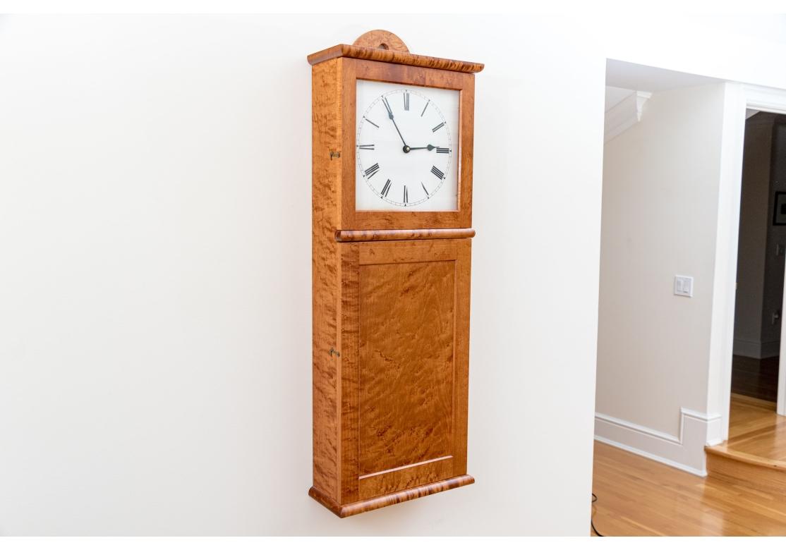 From Connecticut master craftsman shop Ian Ingersoll  Reminiscent of the simplicity of Shaker design with particularly fine chosen Tiger Maple.  Battery operated clock, lower hinged door panel opens to an open cabinet. No weights, pendulum or