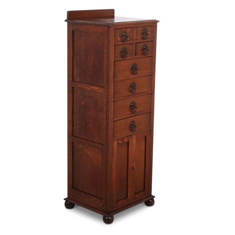 Tiger oak cabinet. Four small drawers over four larger drawers over a two-door storage area at the bottom. The tiger oak has a very distinctive appearance. A very compact and very versatile piece for your home, circa 1910.

Measures: 18? wide x