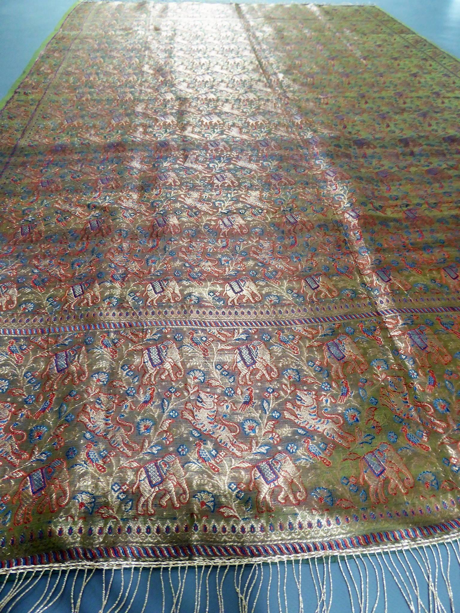 Before 1950

India for the domestic market 

Superb long silk woven shawl made in India for the domestic market probably around 1920/1930. Shawl with a background full of decorations of elephant and tiger garlands, separated at the ends by a red and