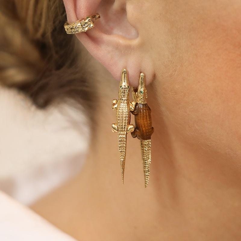 Intricately hand-crafted to replicate an alligator’s body in miniature, this earring is designed in 18k yellow gold, with the alligator’s mouth acting as the closing mechanism to snap onto the ear. The body of the alligator is crafted from tiger's