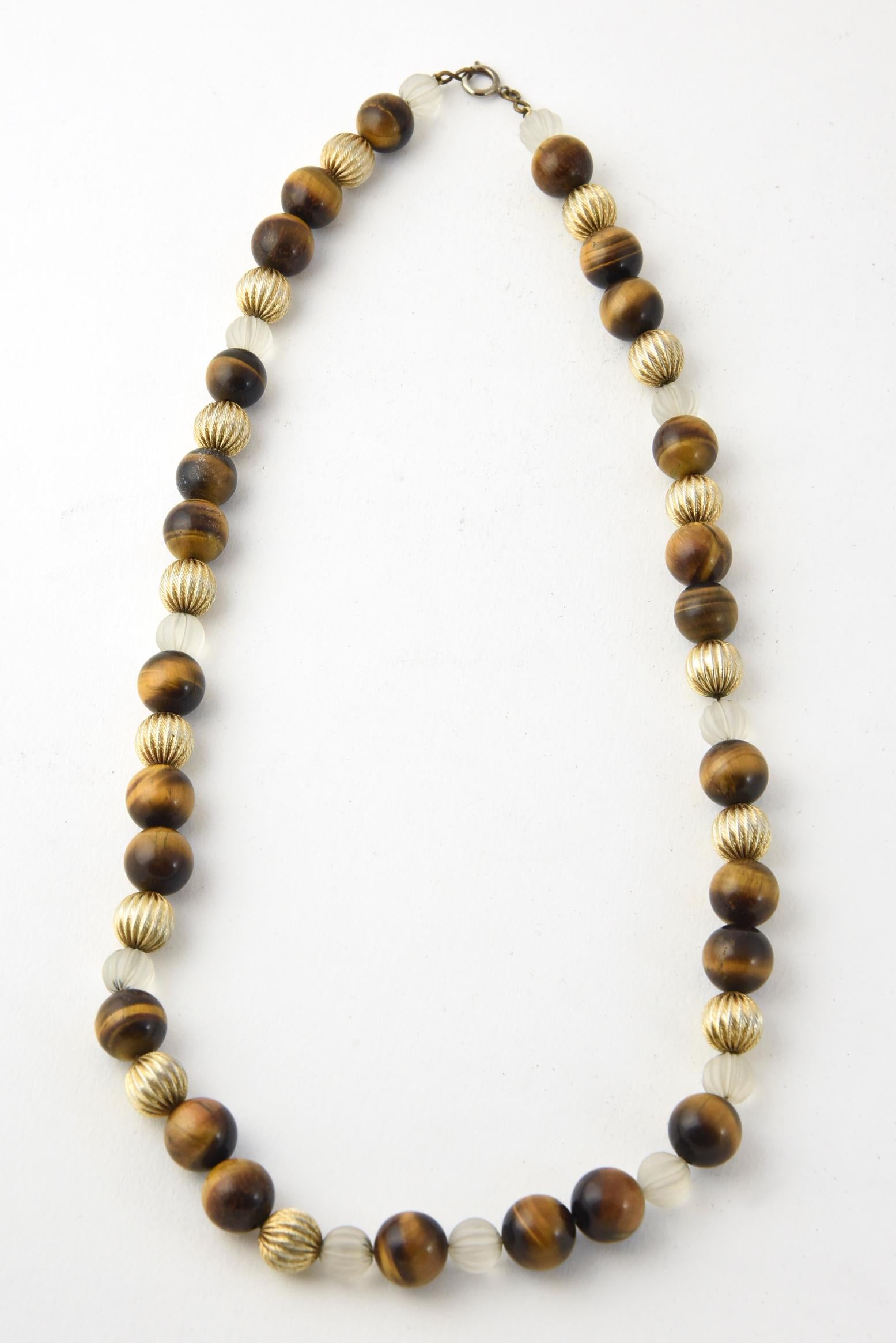 Tiger's eye, carved frosted crystal, and gilt ribbed bead necklace with brass-and-white metal clasp strung on a string. No maker's mark. Age wear.