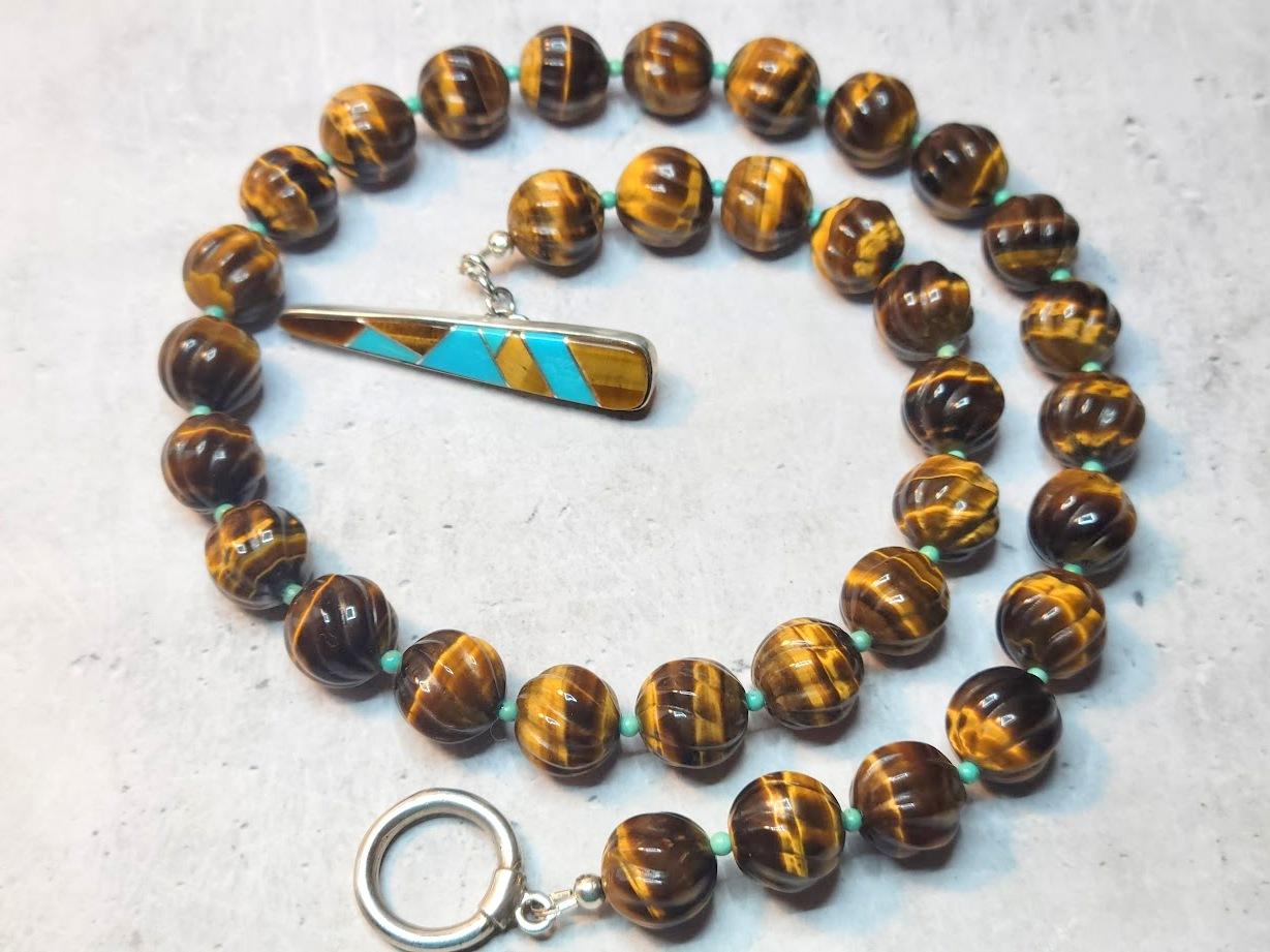 The length of the necklace is 19 inches (48 cm). The size of the
carved round beads is 12 mm. These are lovely hand-carved tiger eye beads. The carving is a sophisticated swirl pattern. The carving is uniform and very nicely done.
The beads' tones