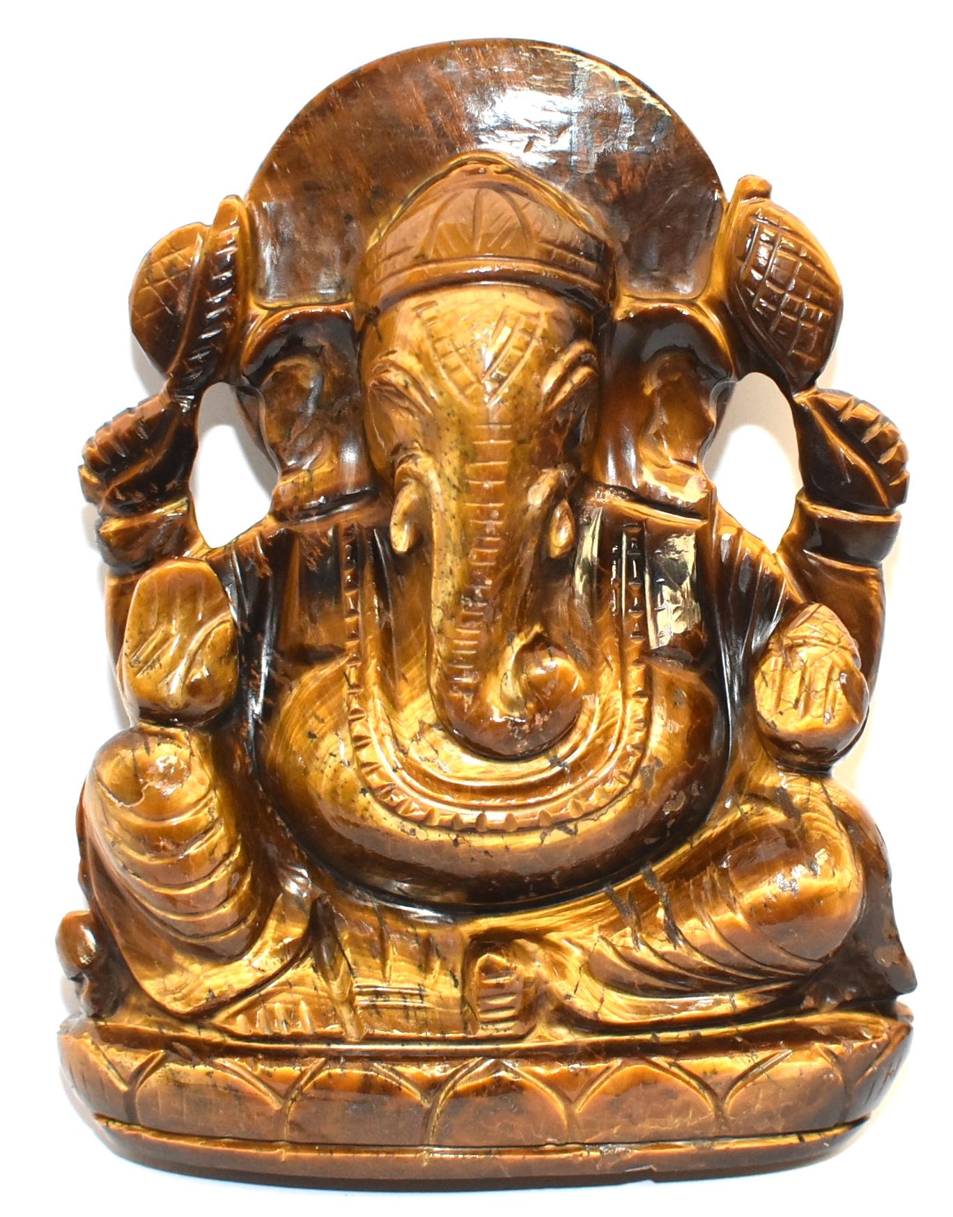 A beautiful hand carved natural tiger's eye sculpture depicting the God Ganesh. Seated on a lotus throne, the 4-armed Ganesh is holding his various attributes. This statue is carved out of one piece of fine grade tiger's eye demonstrating fantastic