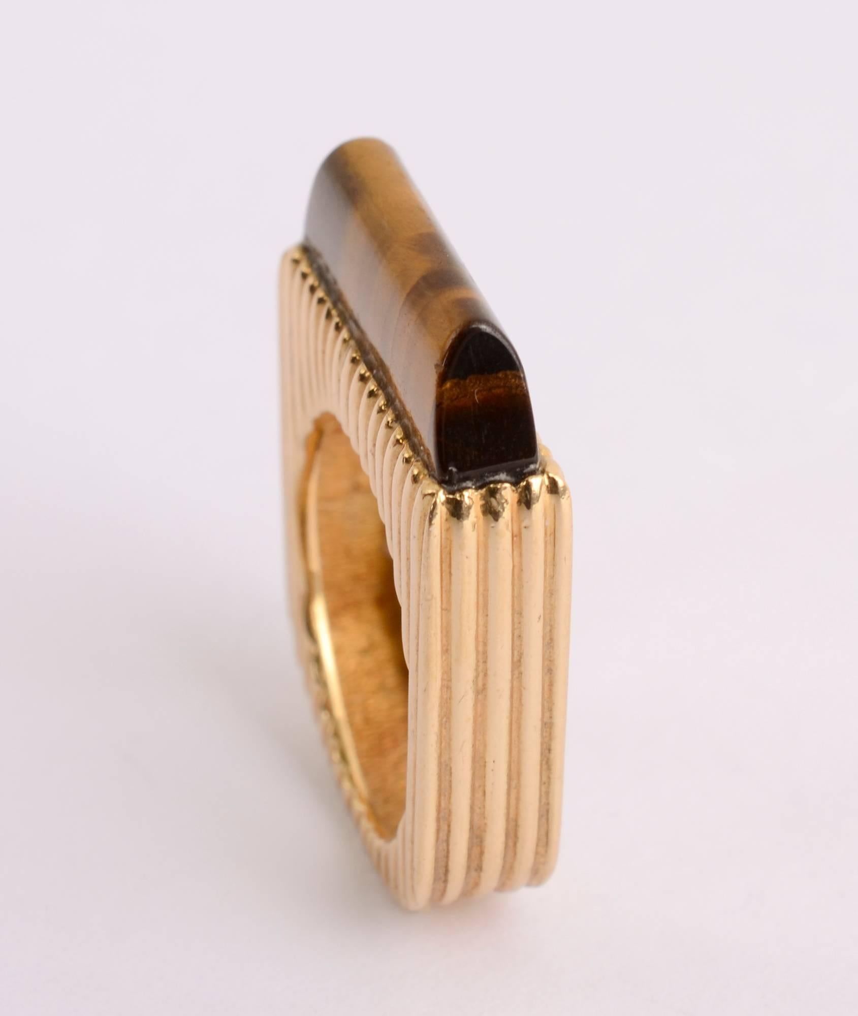 Stylish modernist 18 karat gold ring with tiger's eye. It's interesting that it is very much in the style of Dinh Van (although not the price tag) and it has the maker's initials DY. I do not recognize them
The gold is striated throughout. The stone