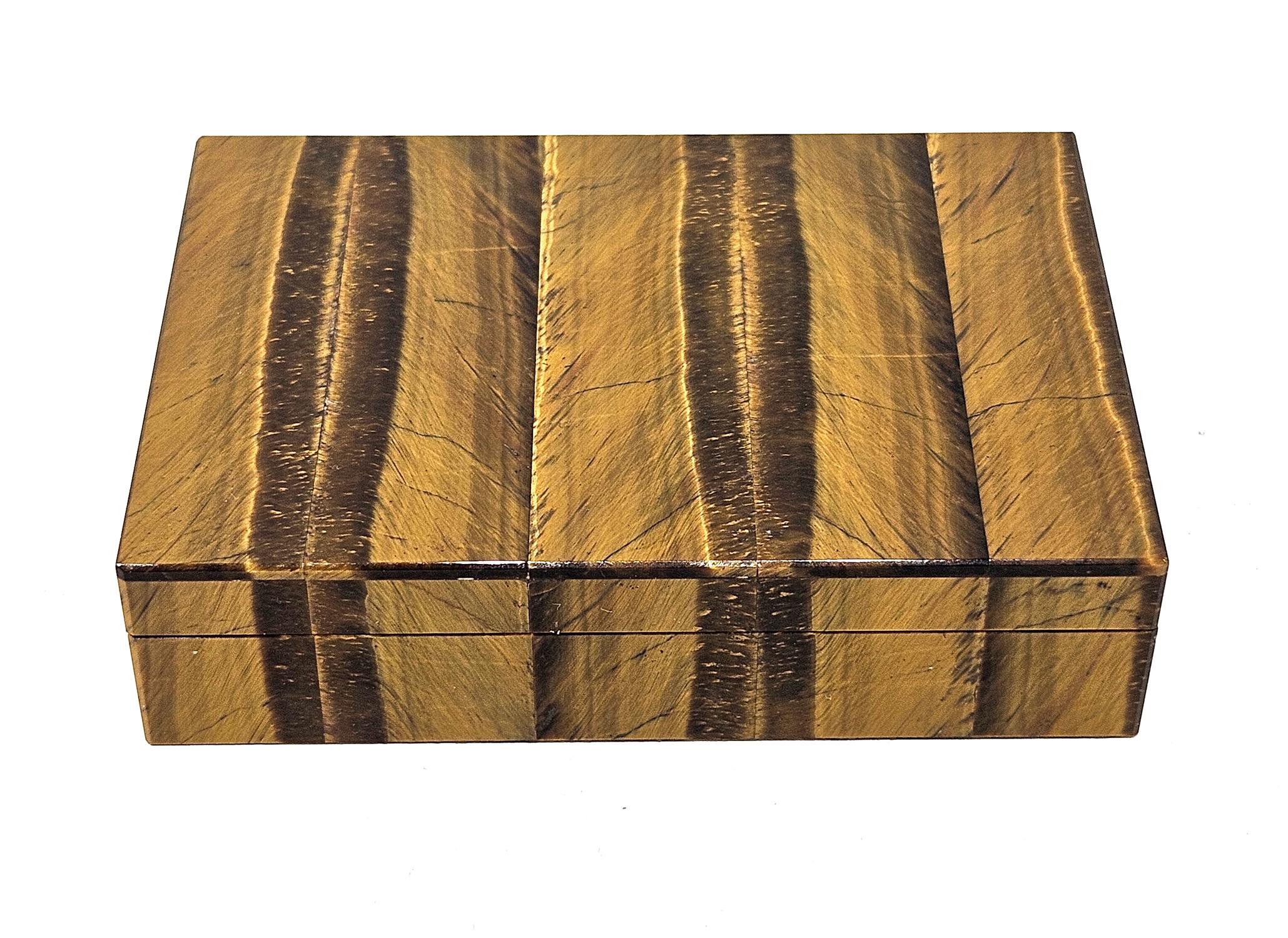 Une exquise boîte italienne vintage en intarsia œil de tigre estampillée par Gori & Zucchi (devenu UnoAErre), vendue au détail à Ravenne vers les années 1960. 
Le coffret est plaqué de quartz œil de tigre finement rubané, avec un magnifique motif et