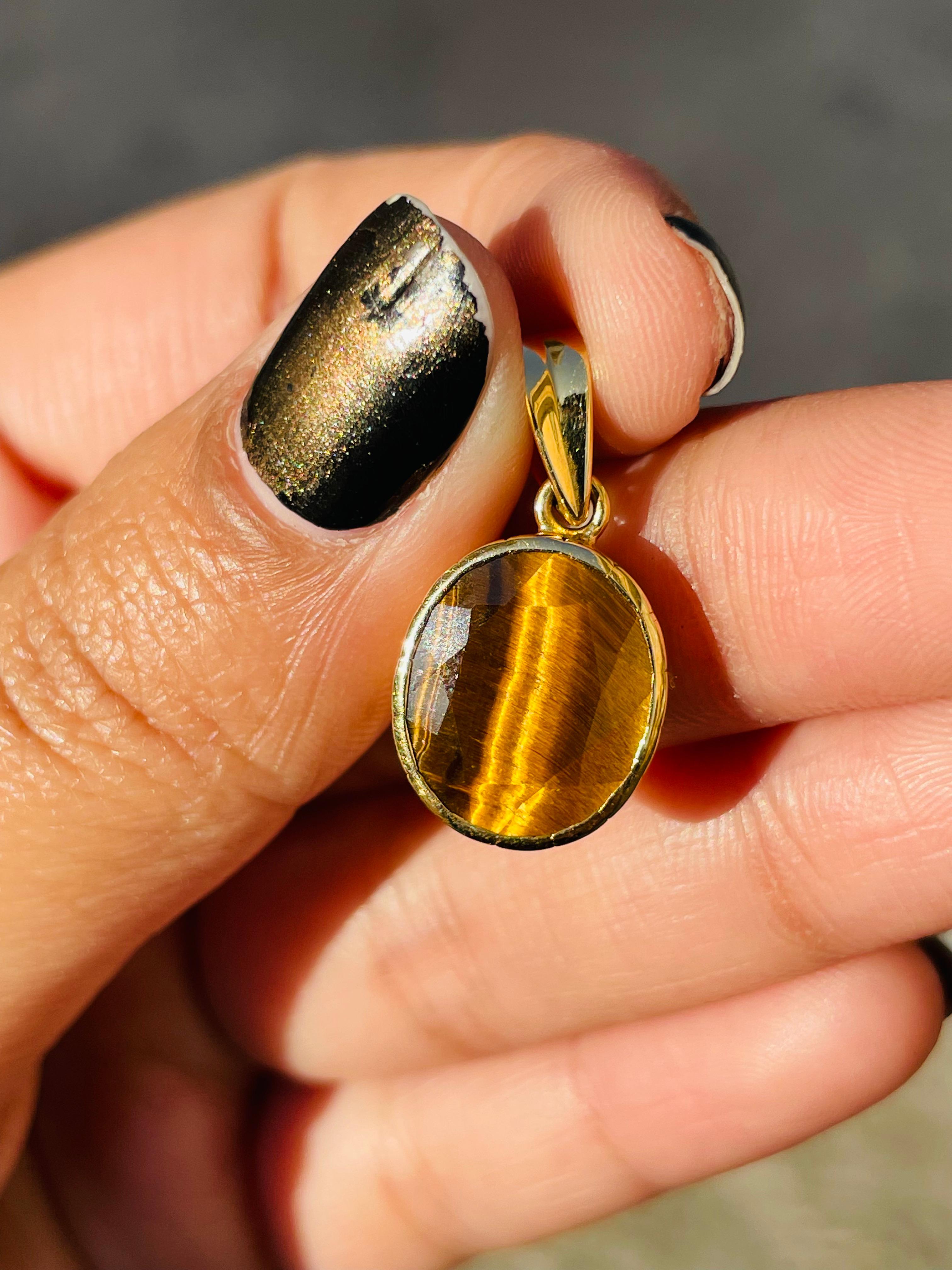 Tiger's eye pendant in 18K Gold. It has a oval cut gemstone that completes your look with a decent touch. Pendants are used to wear or gifted to represent love and promises. It's an attractive jewelry piece that goes with every basic outfit and