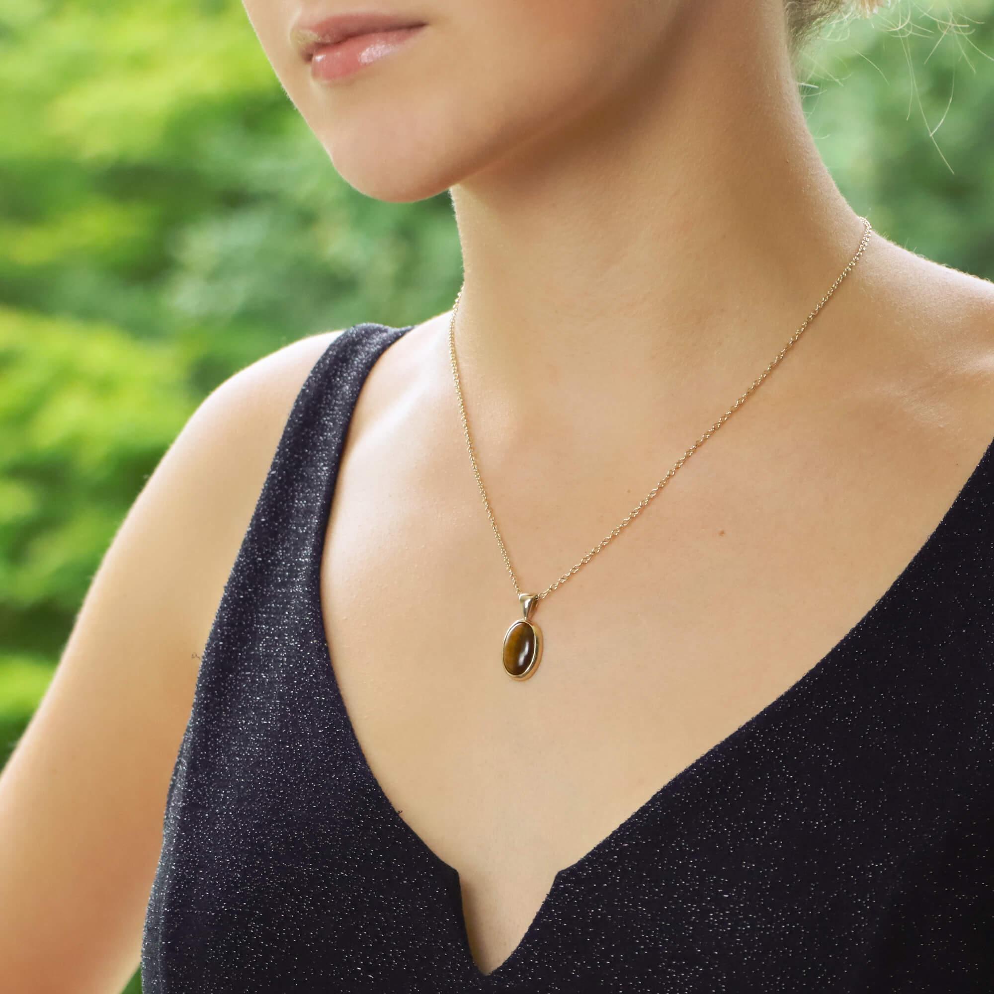 A beautiful cabochon tiger’s eye pendant set in 9k yellow gold.

The pendant solely features a mesmerizing cabochon tiger’s eye which vis simply bezel set securely in 9k yellow gold. The pendant hangs from a matching 9k yellow gold trace chain. The