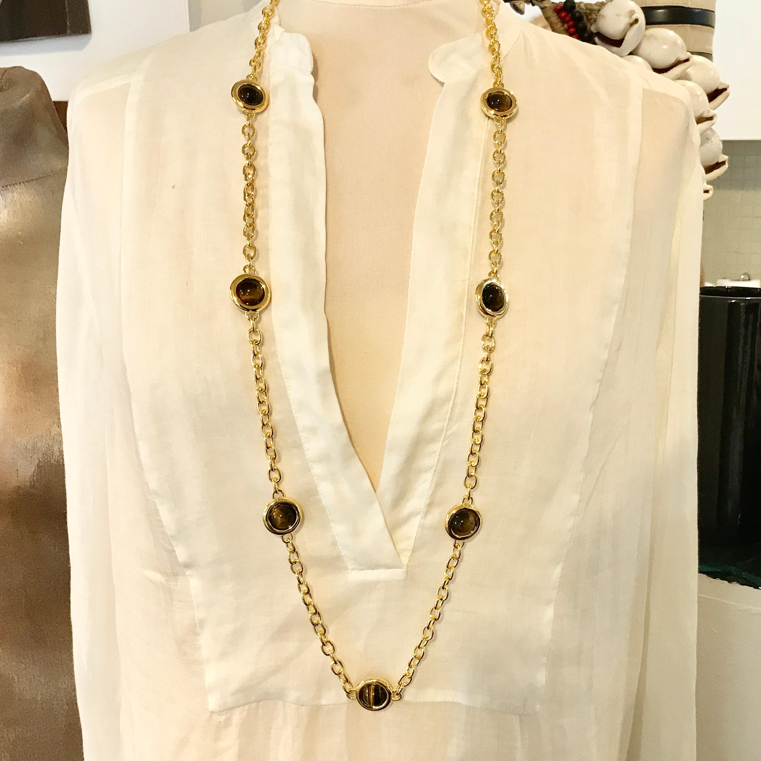 A wonderfully simple yet stylish gems long chain. 

The heavy oval belcher link chain divided by 7 rounded collets set at both sides with a fabulous round cabochon Tiger's Eye gemstone, ending in a 'T-Bar' toggle clasp.

This is a very substantial