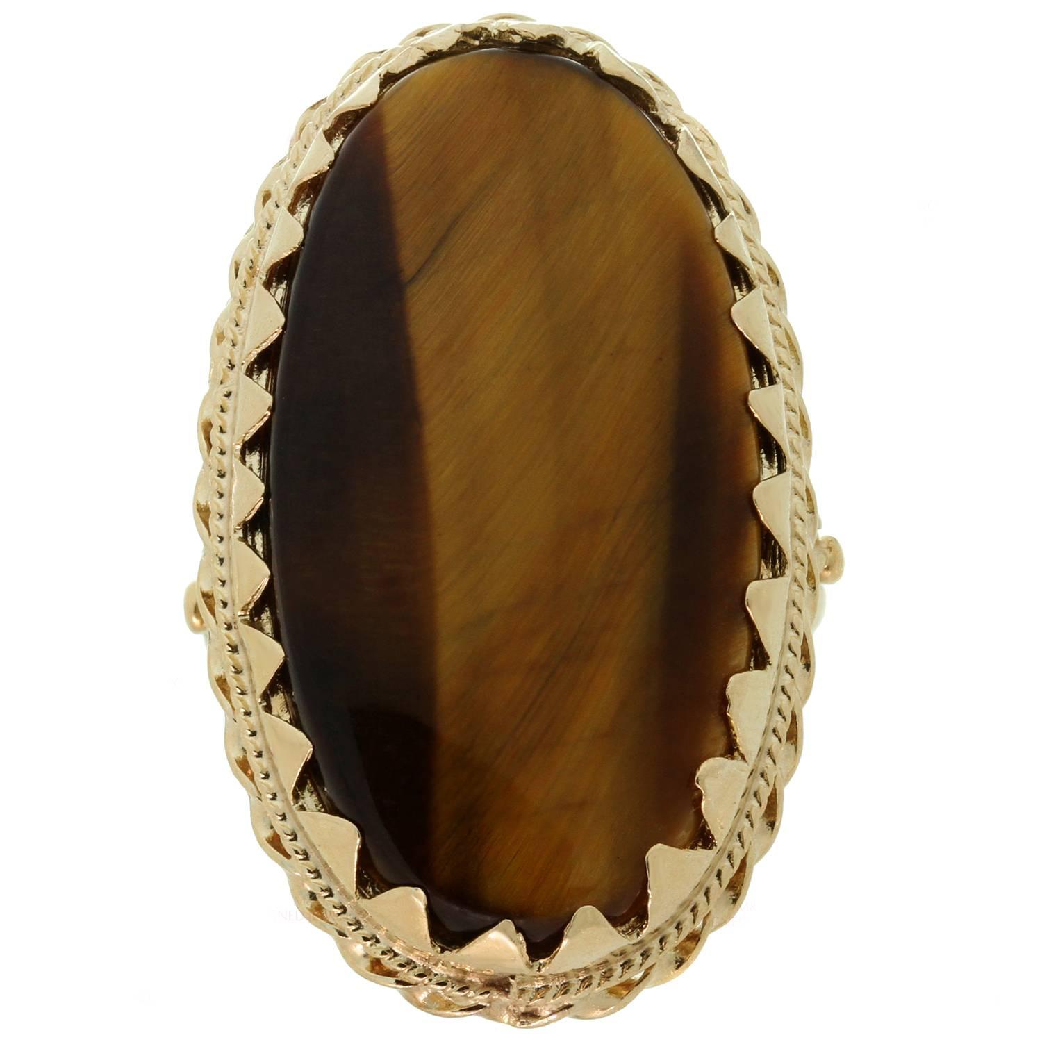 This elegant vintage ring is crafted in 14k yellow gold and beautifully accented with an oval Tiger's eye. Made in United States circa 1970s. Measurements: 0.78