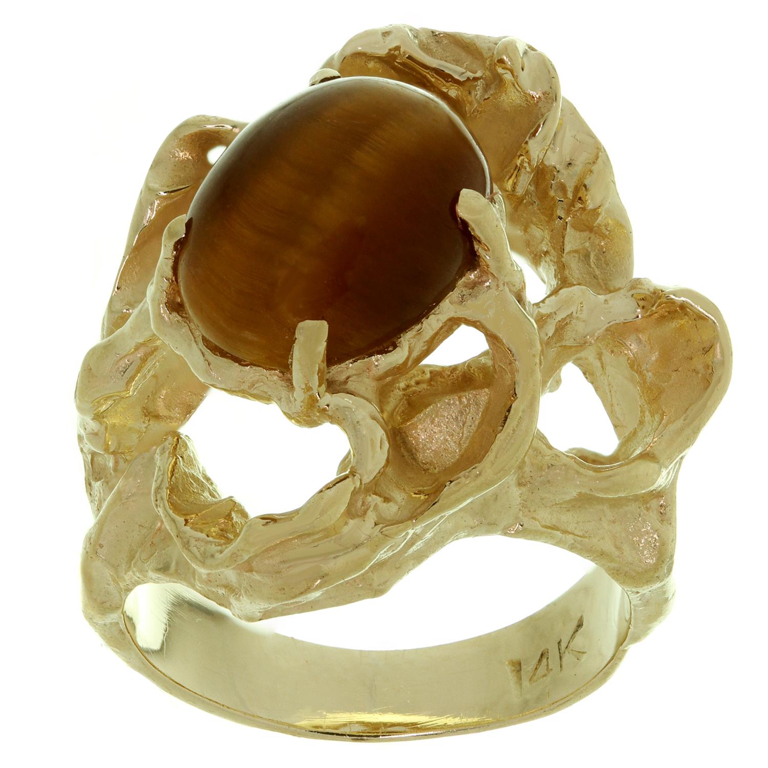 This classic estate nugget ring is crafted in 14k yellow gold and set with a tiger's eye stone in the center. Made in United States circa 1980s. Measurements: 0.74
