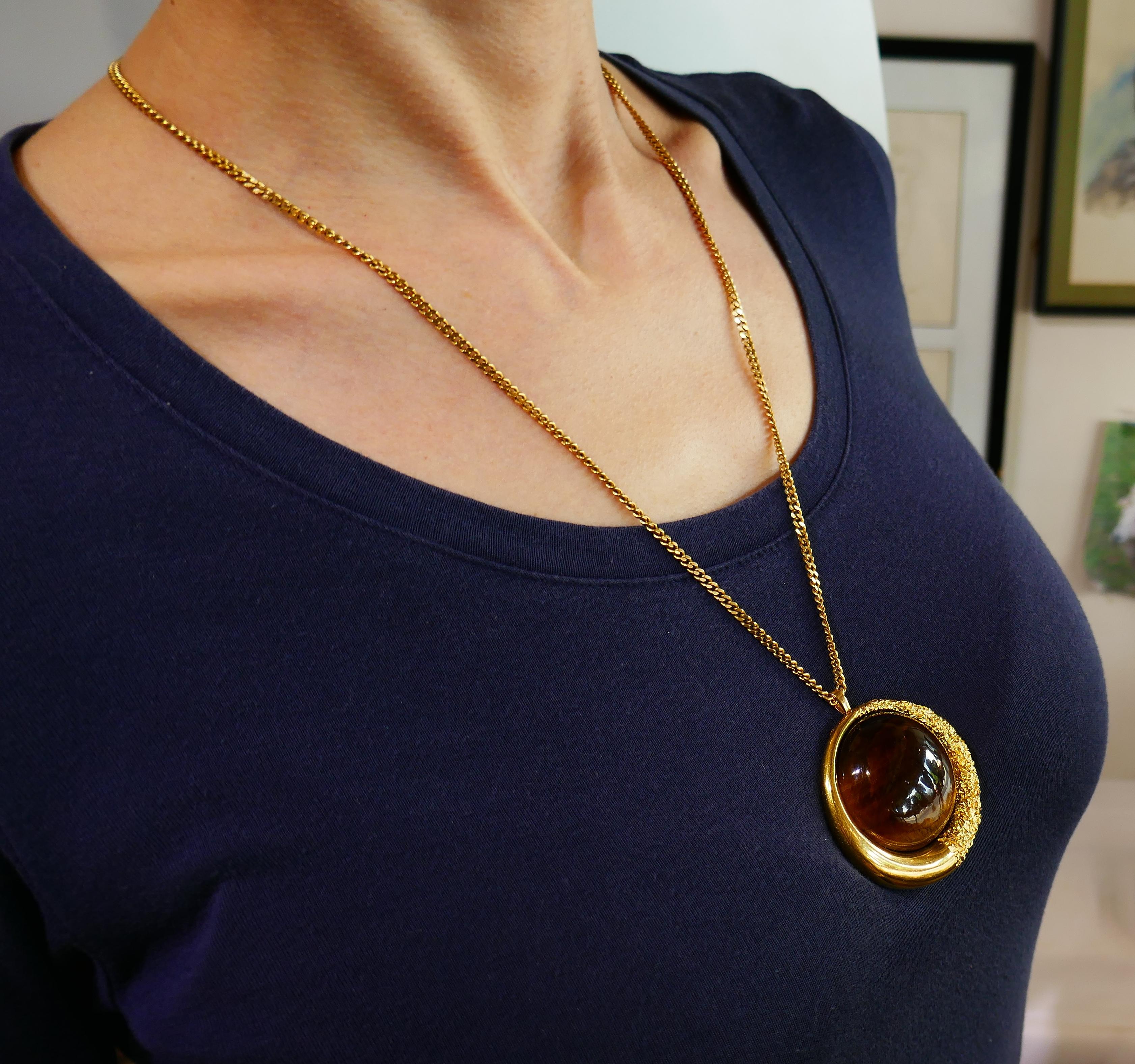 Bold and articulated pin/ pendant created in France in the 1970s. 
The pendant is made of 18 karat (tested) yellow gold and tiger's eye. 
The pendant measures 2 inches (5 centimeters) in diameter and weighs 46.8 grams. 
The tiger's eye part measures