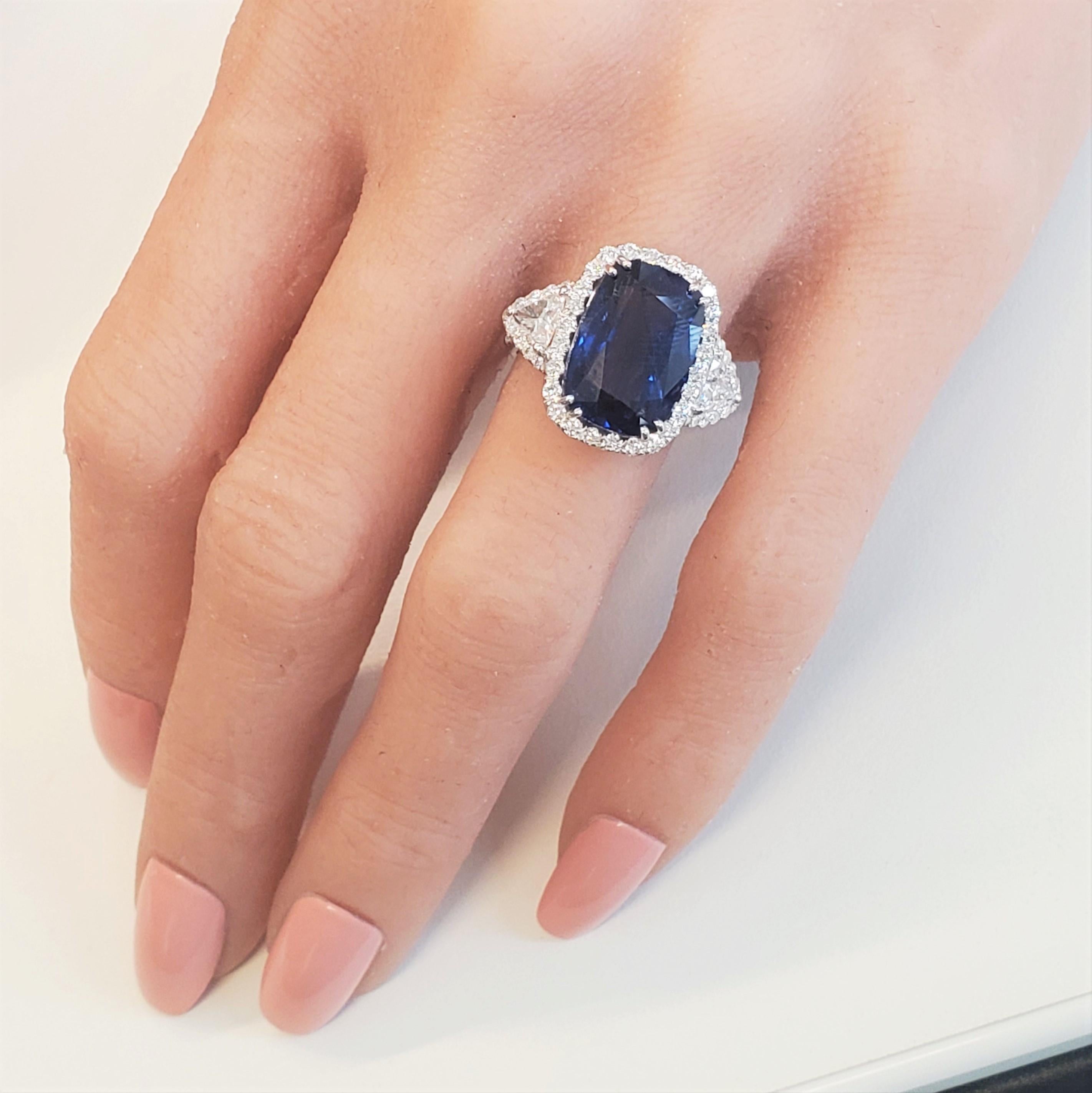 This show-stopping 18k white gold cocktail ring is the ultimate selection for your next anniversary, wedding, or engagement occasion. One cushion cut, fine quality intense blue sapphire is prong set in the center with a weight of 10.11 carats. The