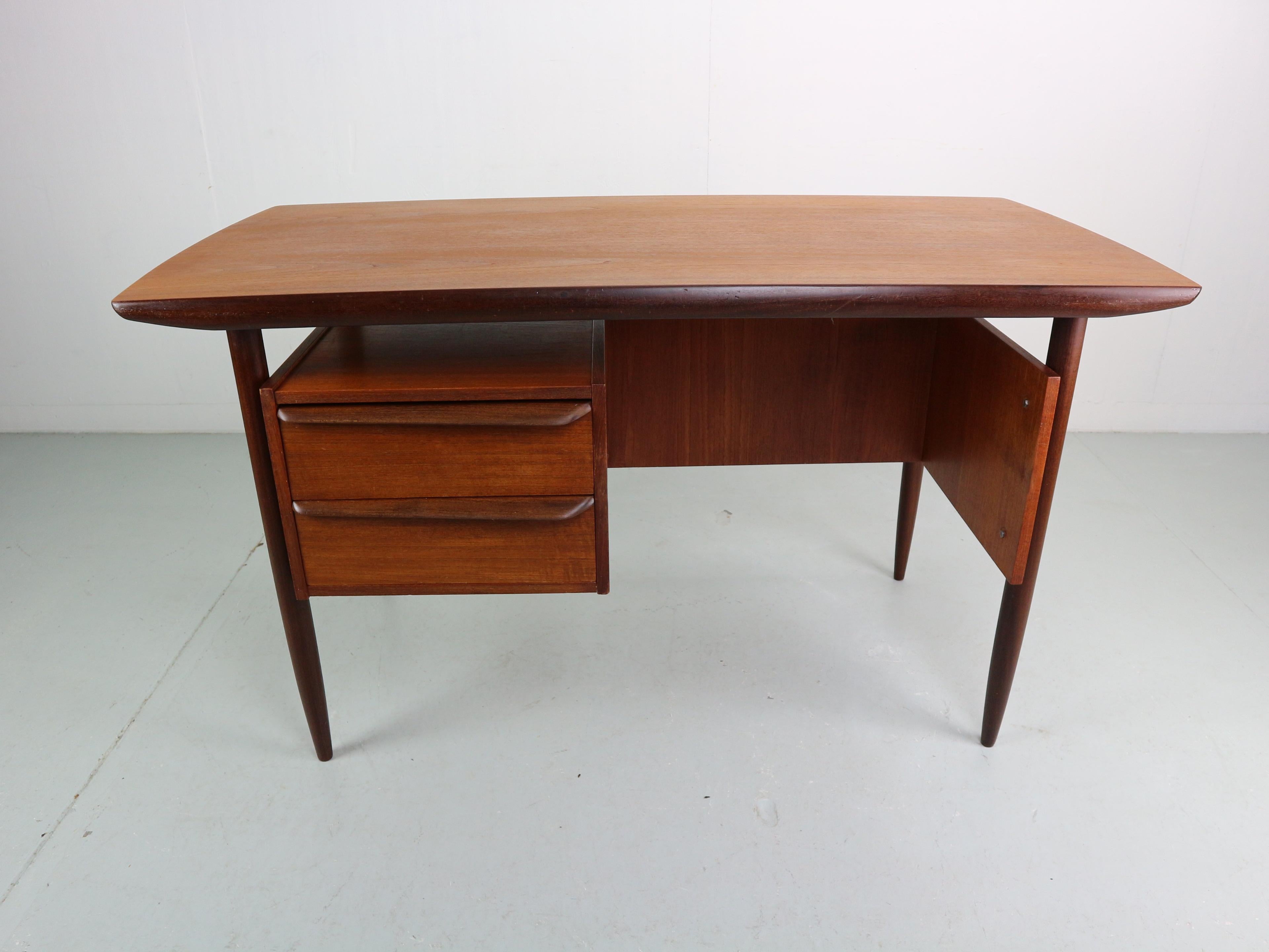 Teak writing desk produced by Hulmefa in the 1960s and designed by Tijsseling, Netherlands. The desk has two drawers. There’s a book shelve at the back for storage or display. The desk is in a good condition.