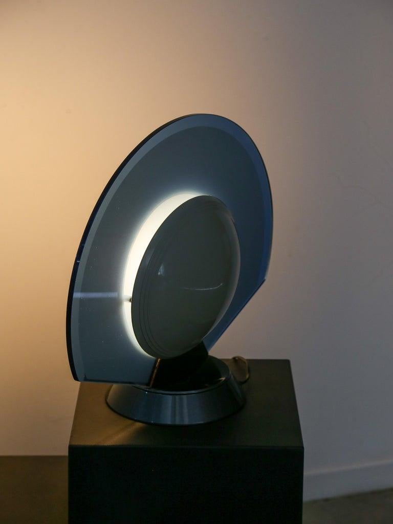 The Tikal model table lamp, created by Pier Giuseppe Ramella around 1985, is an exceptional lighting room that combines a unique aesthetic with practical functionality. Featuring a distinctive design typical of that time, this lamp embodies the